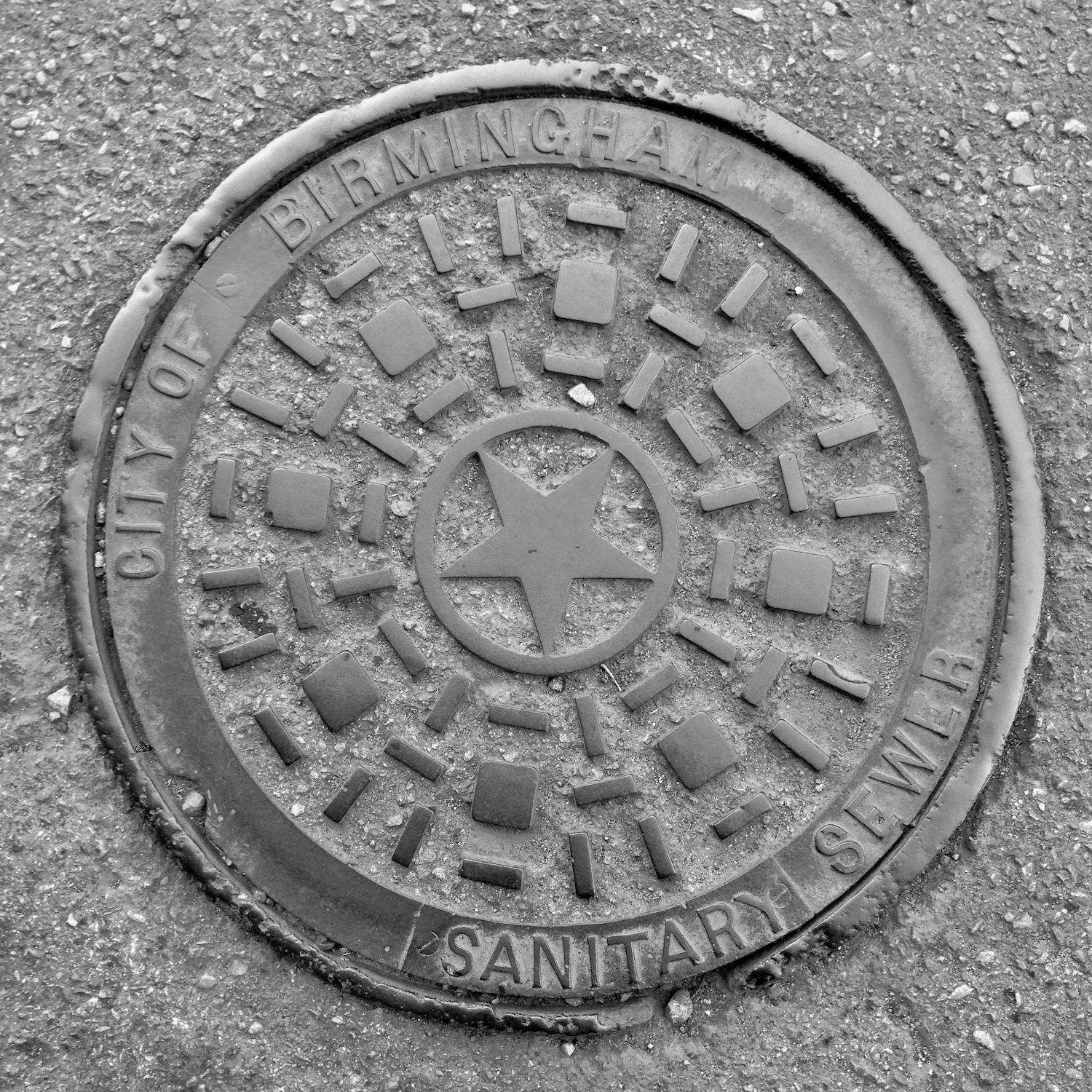 black and white image of a utility cover