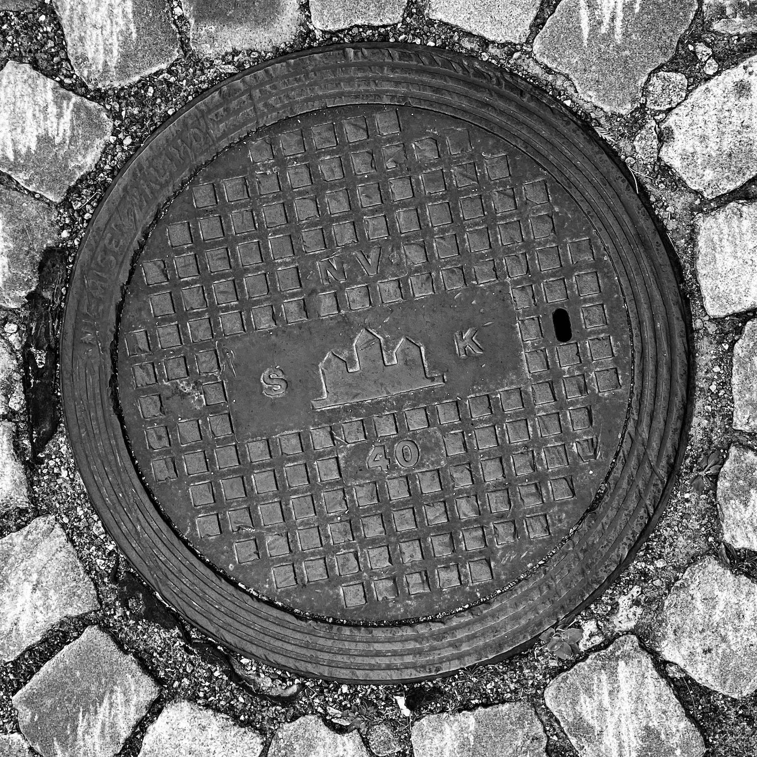 black and white image of a utility cover