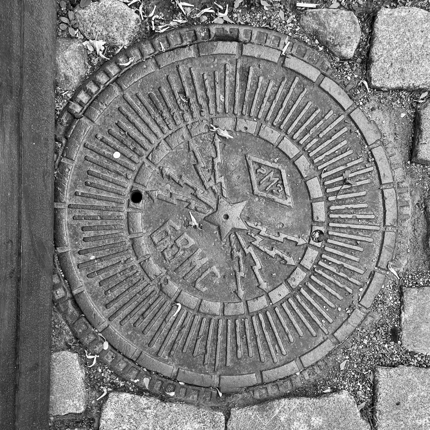 black and white image of a utility cover