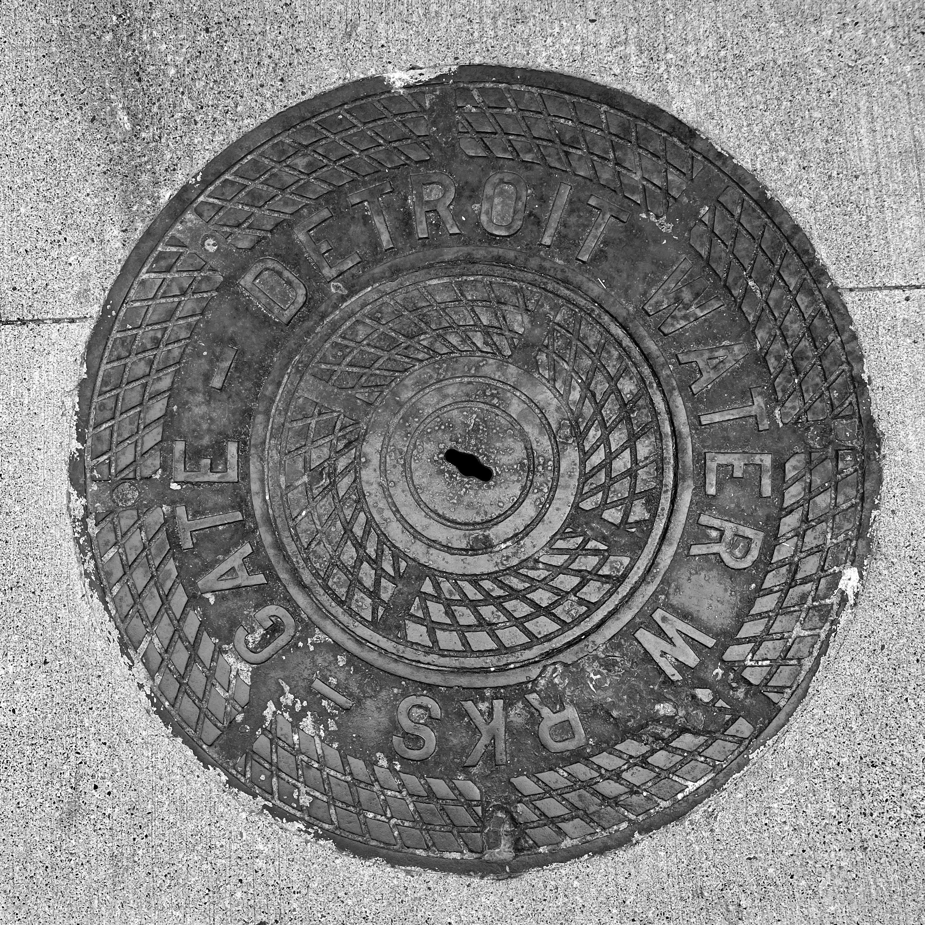 black and white image of a utility cover