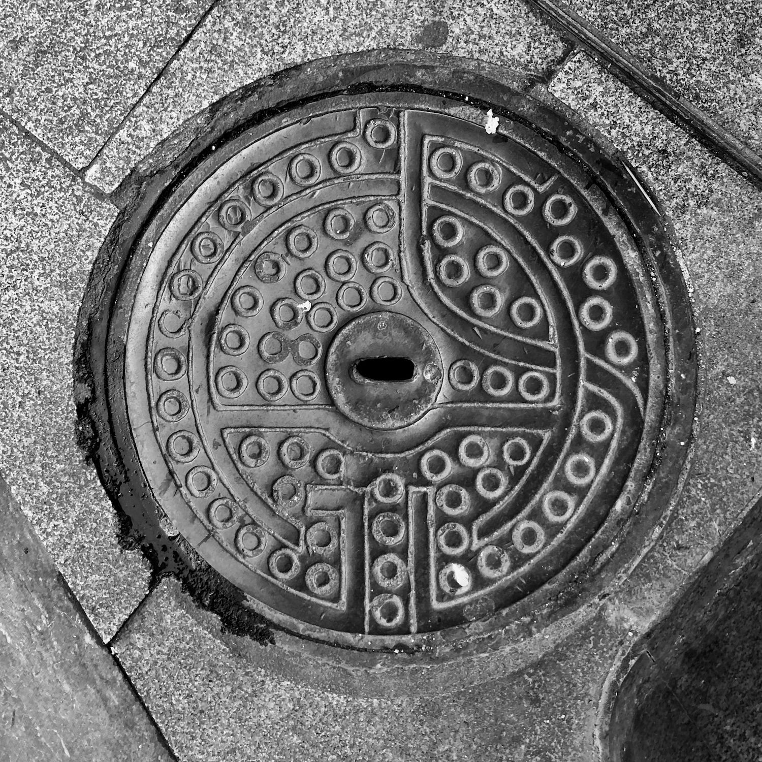 black and white image of a utility cover