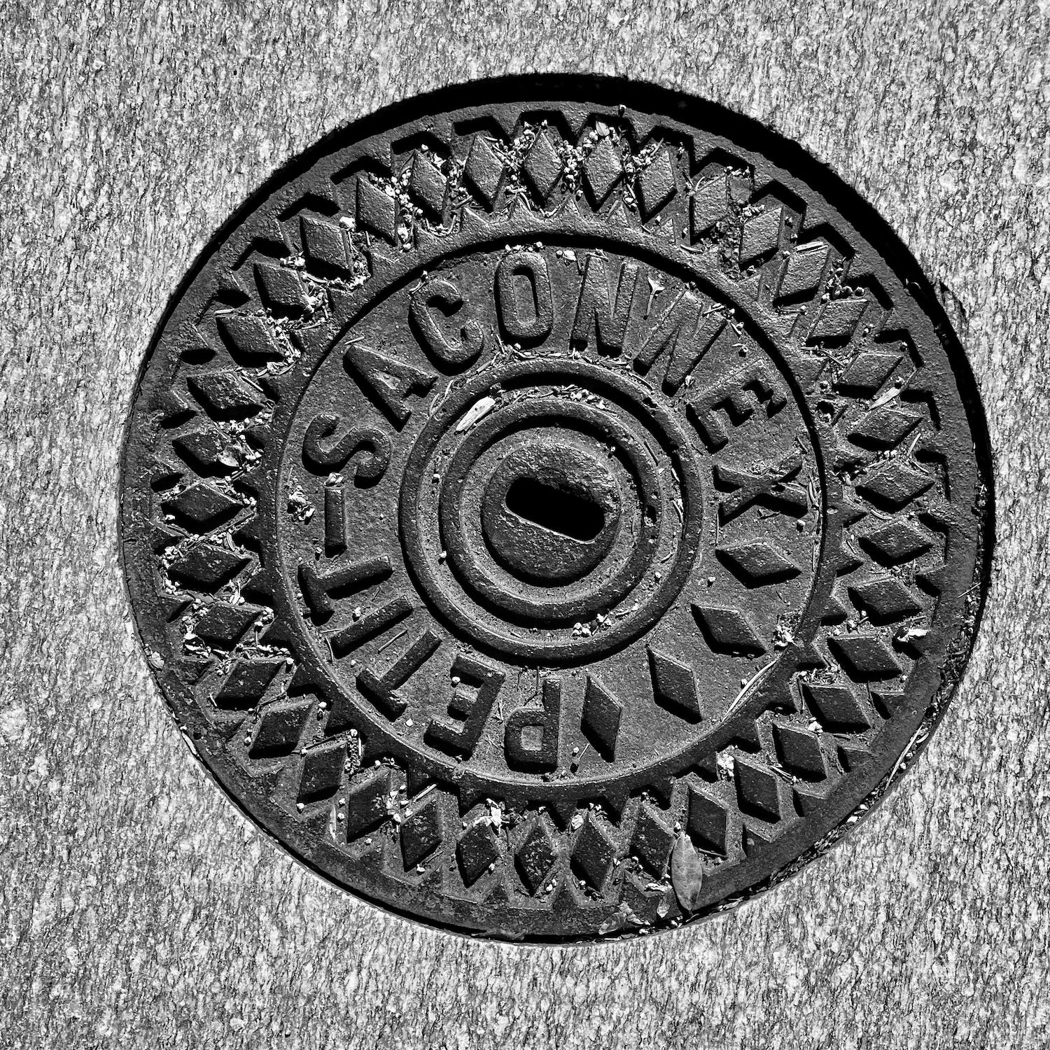black and white image of a utility cover