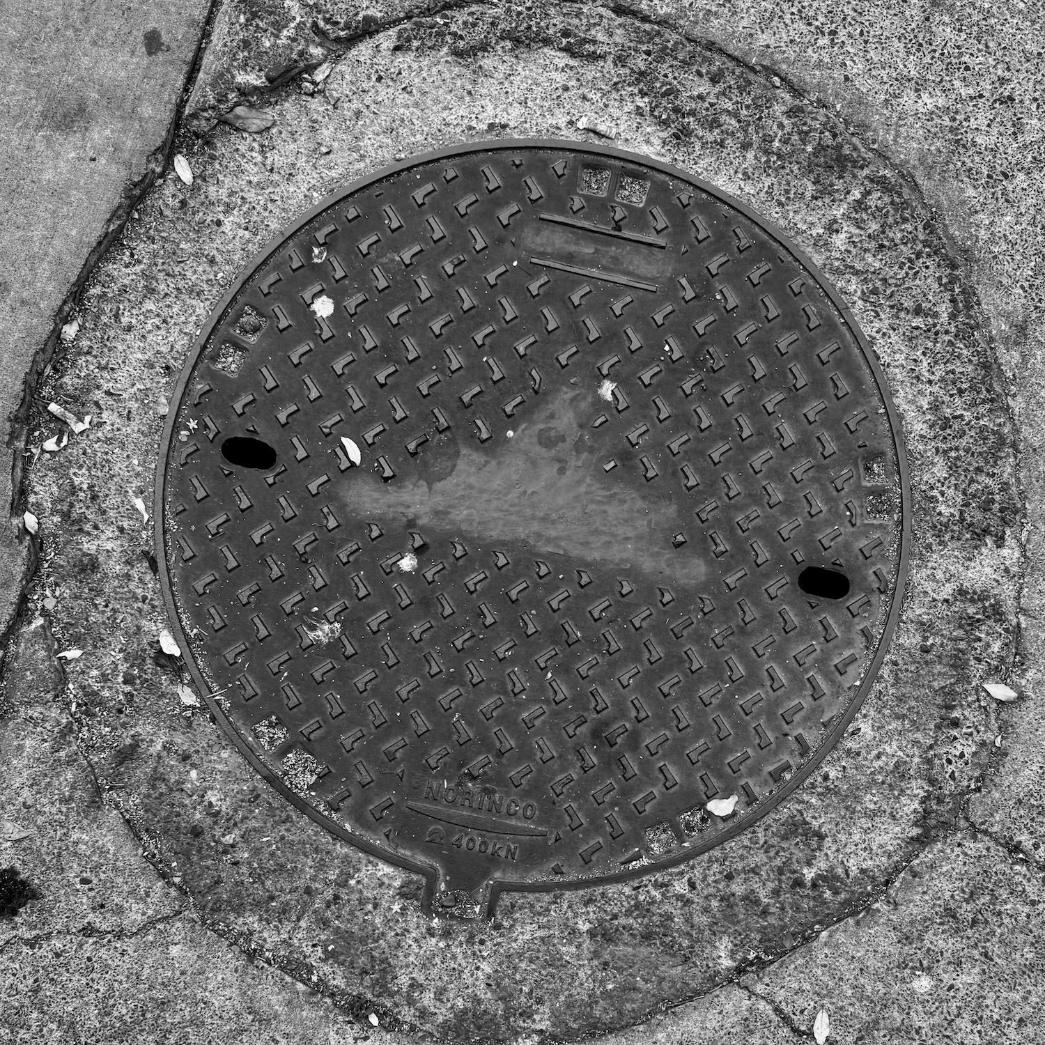 black and white image of a utility cover