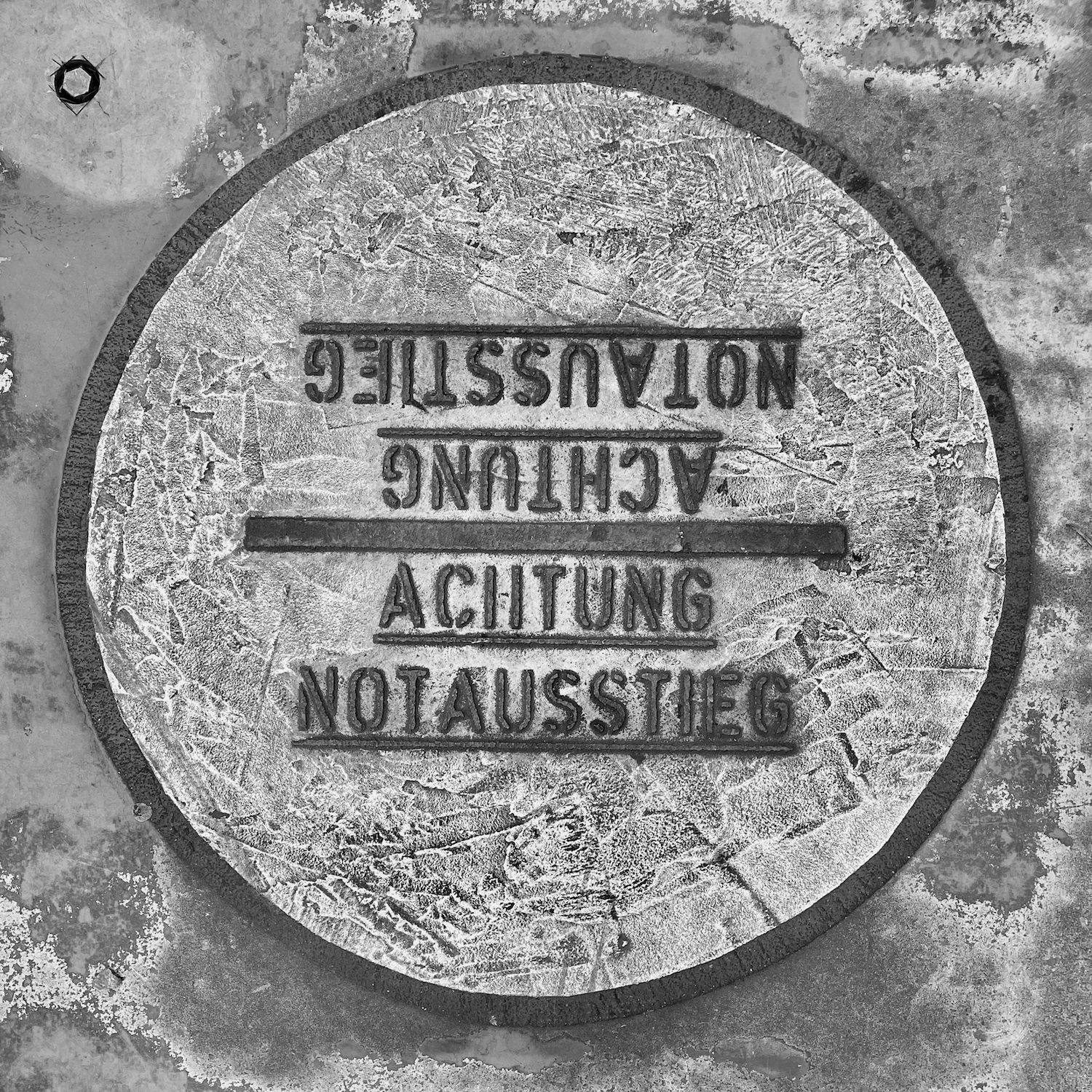 black and white image of a utility cover