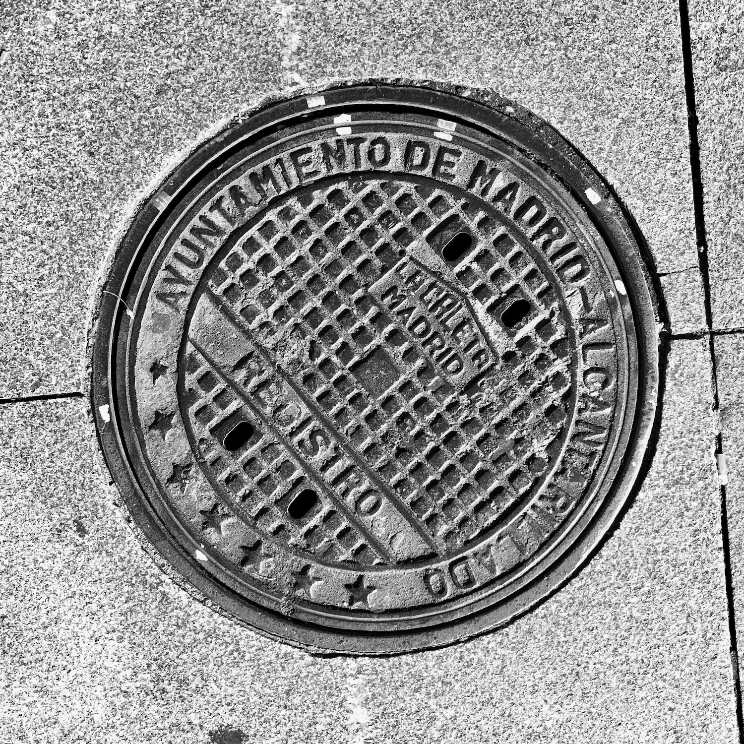 black and white image of a utility cover