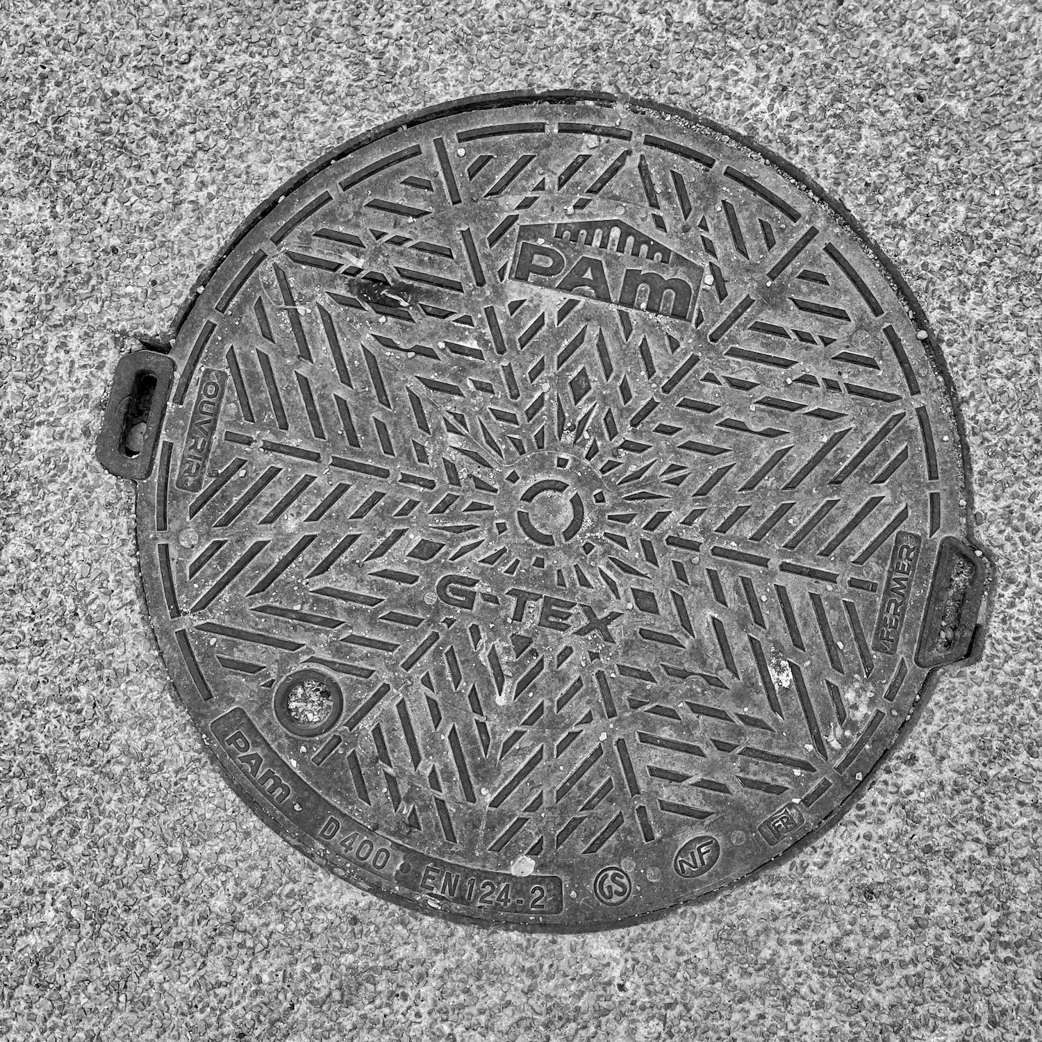black and white image of a utility cover