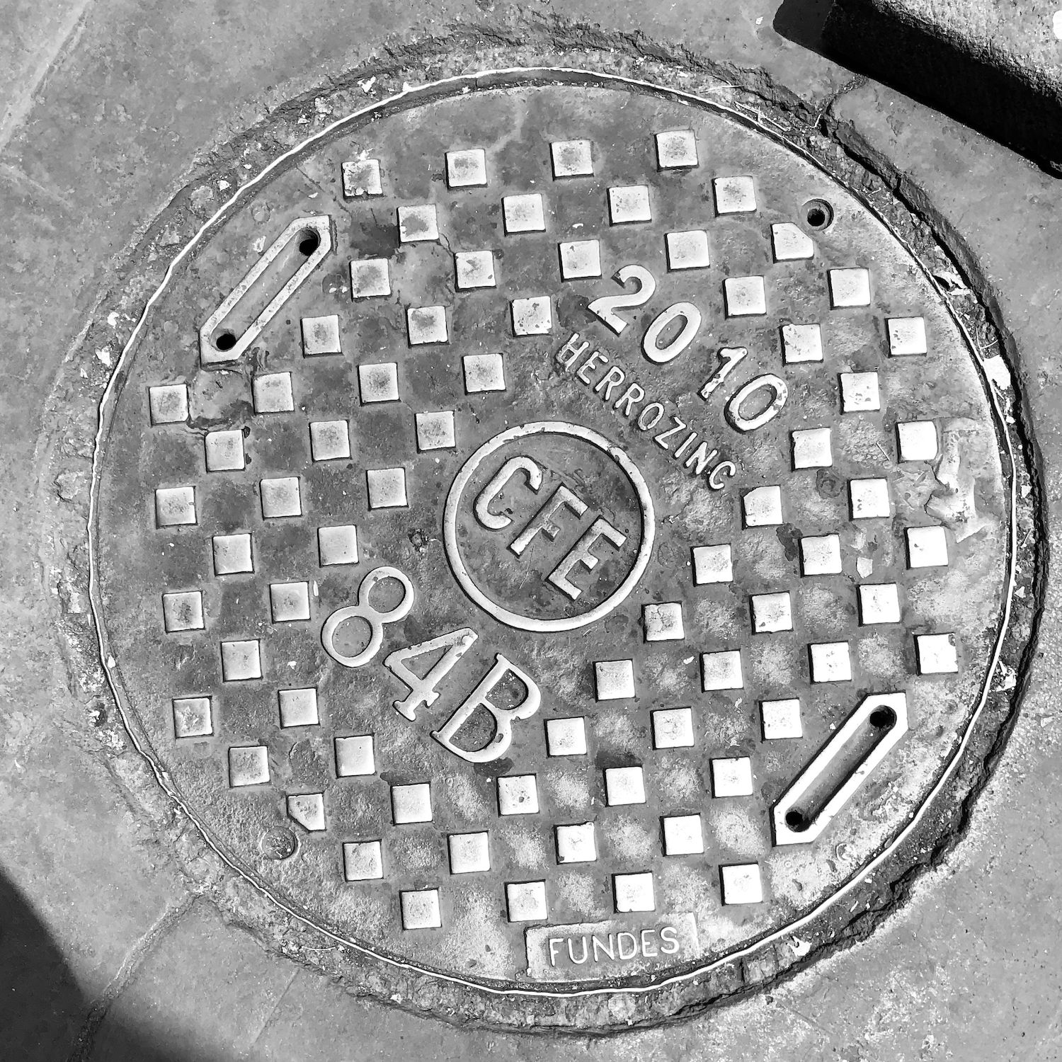 black and white image of a utility cover