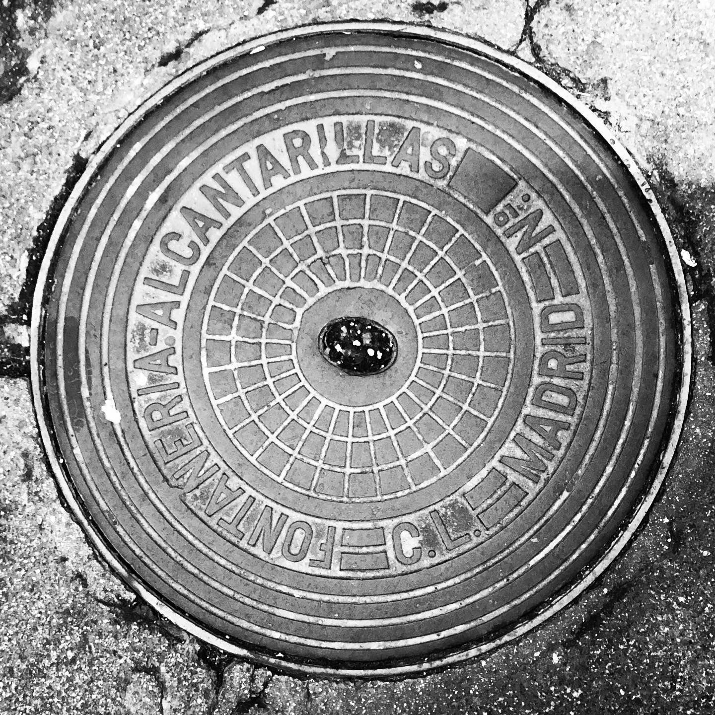 black and white image of a utility cover