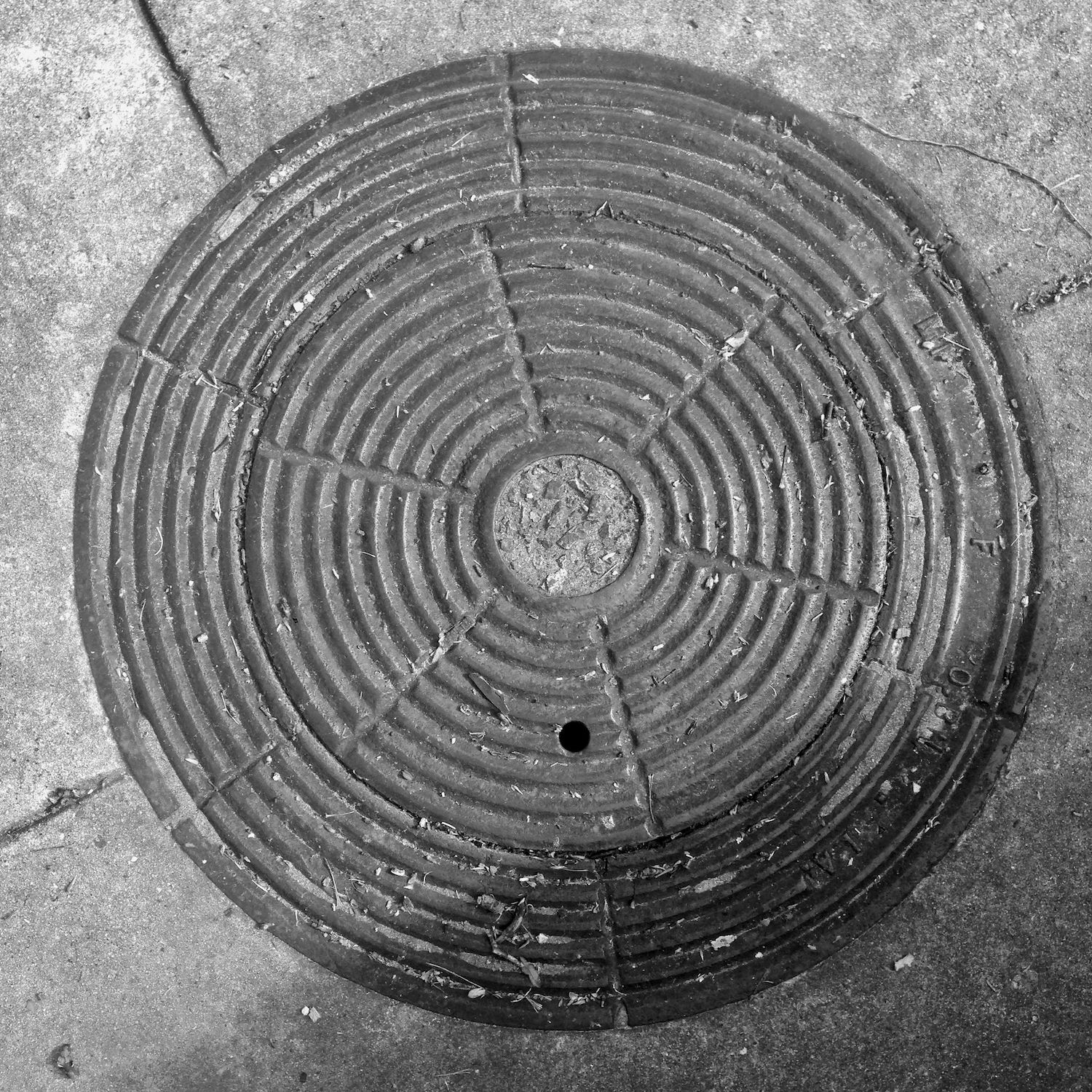 black and white image of a utility cover
