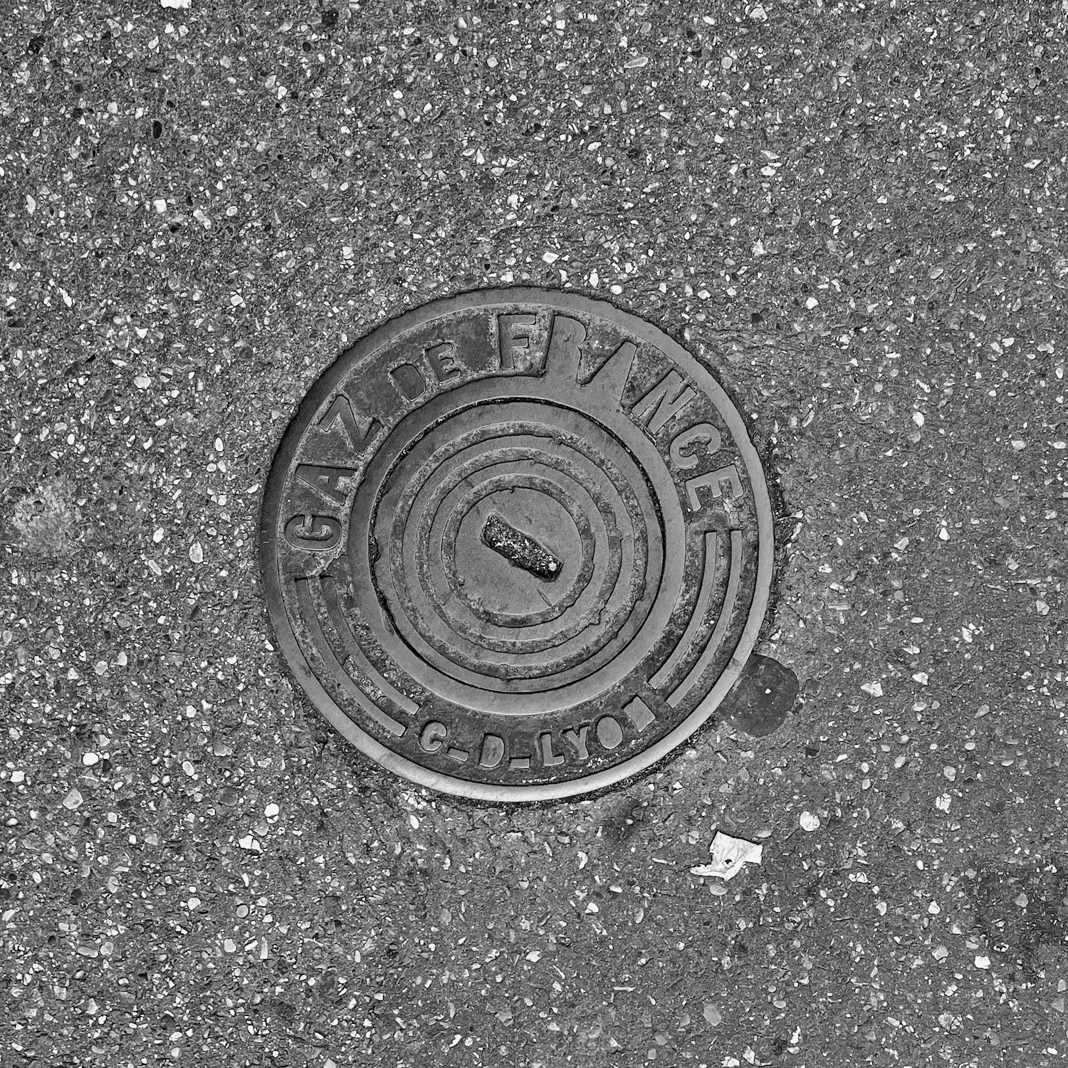 black and white image of a utility cover