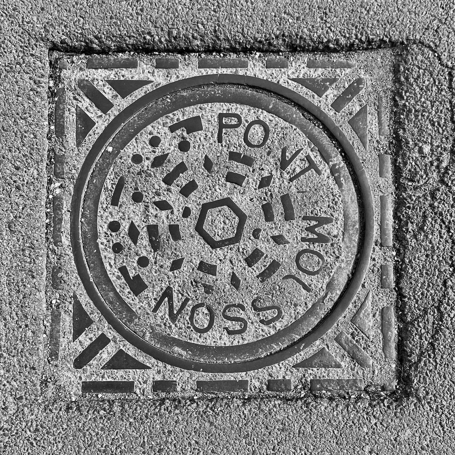 black and white image of a utility cover
