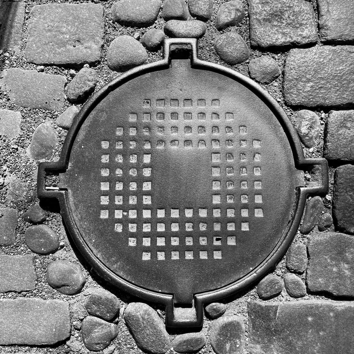 black and white image of a utility cover