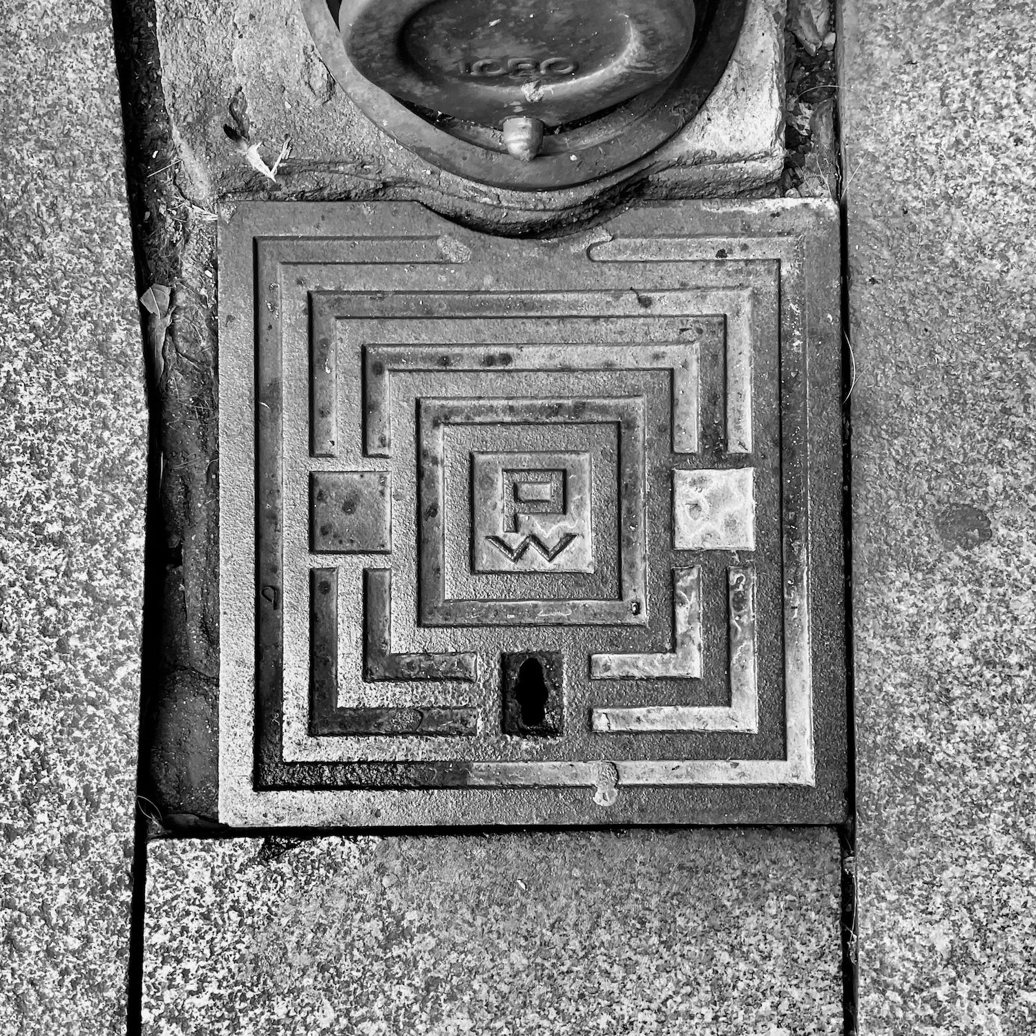 black and white image of a utility cover