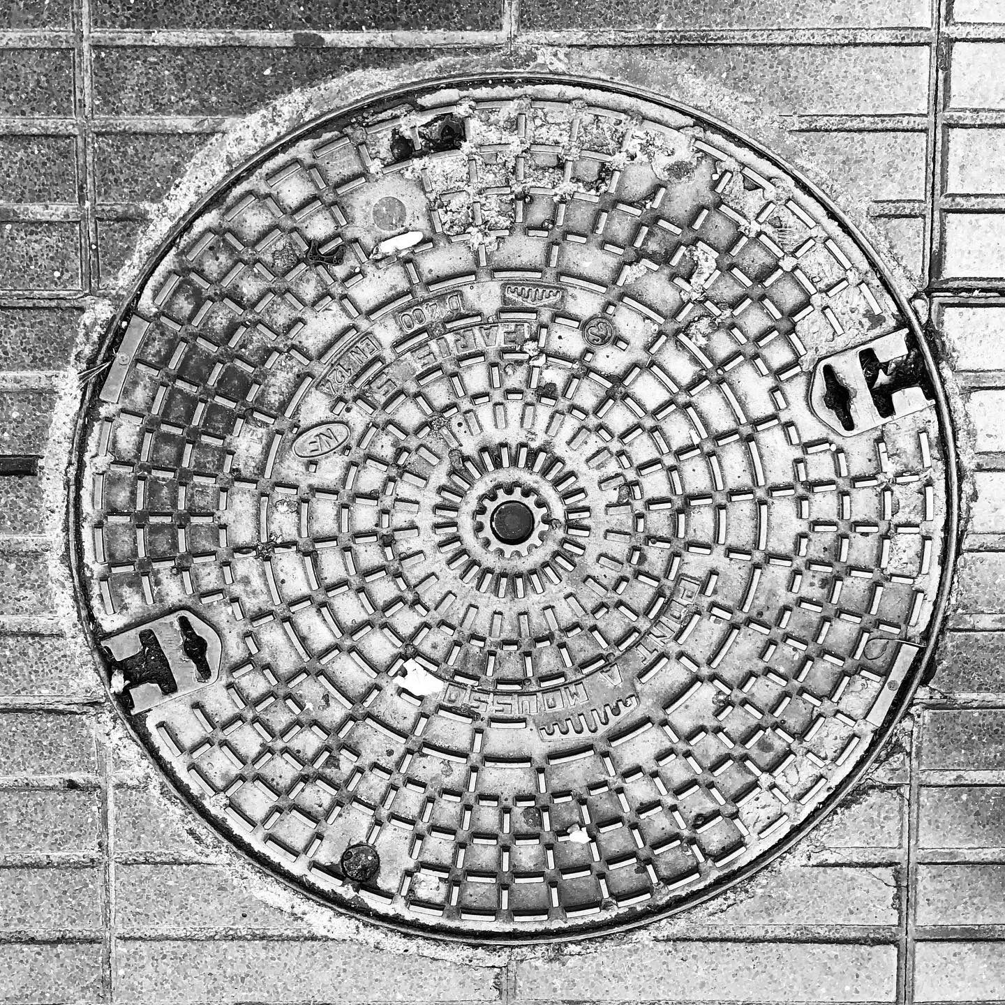 black and white image of a utility cover