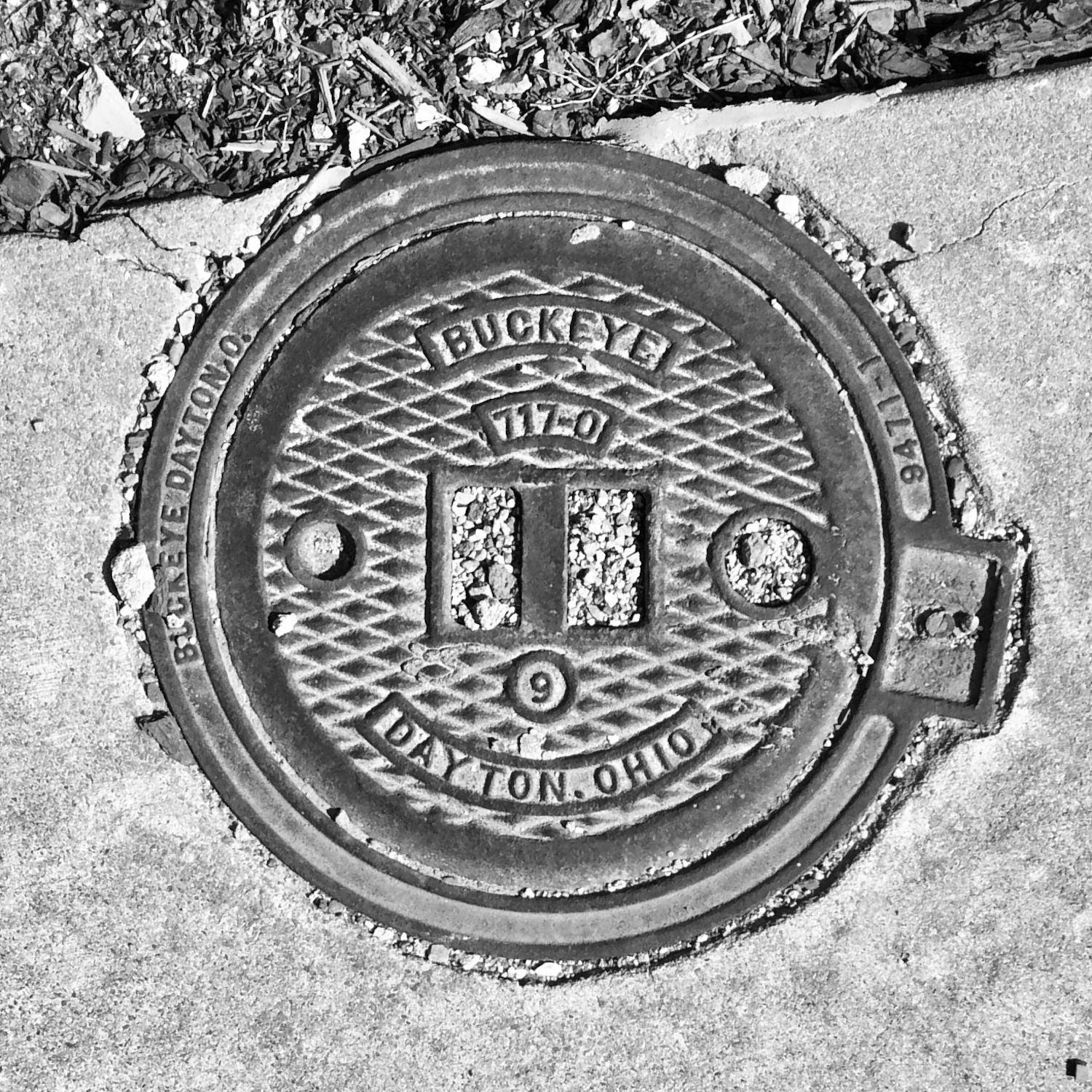 black and white image of a utility cover