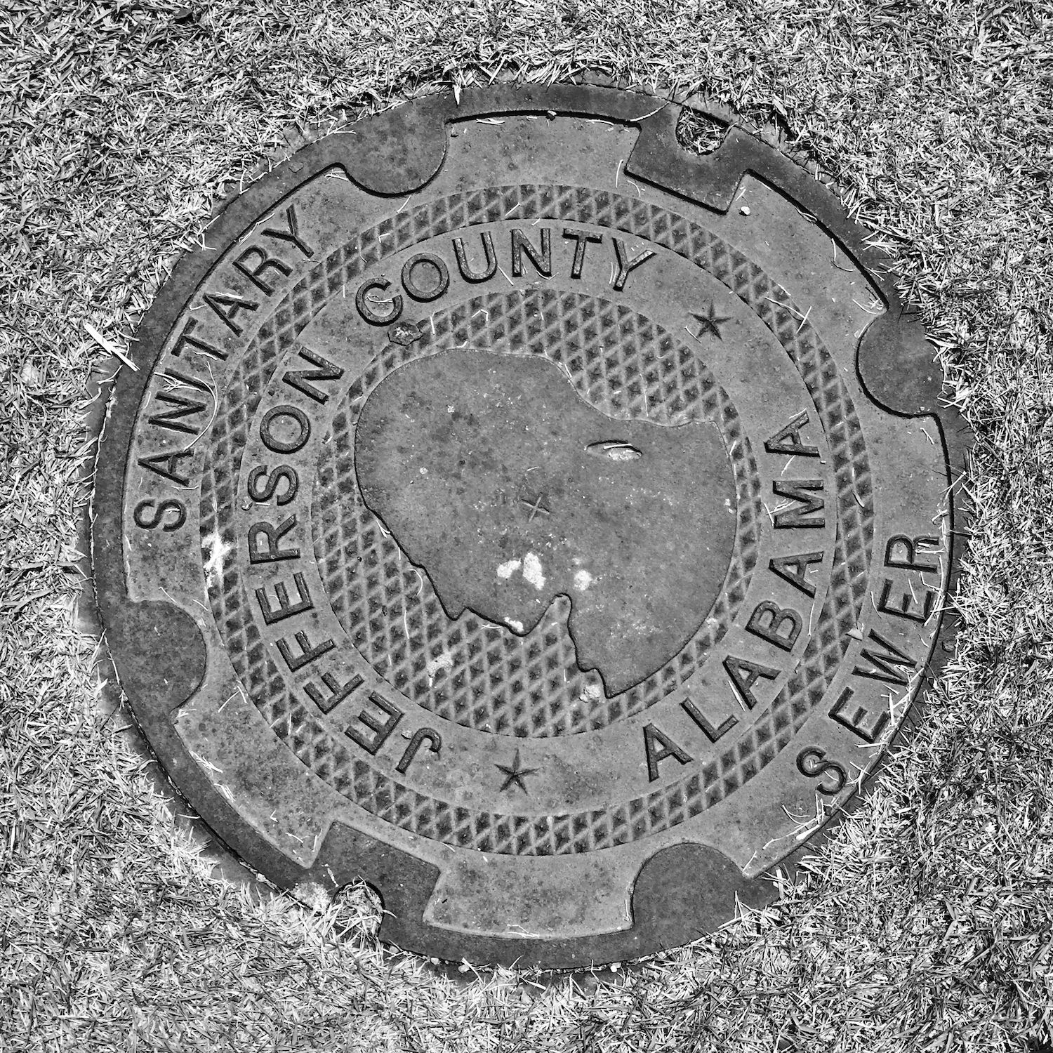 black and white image of a utility cover