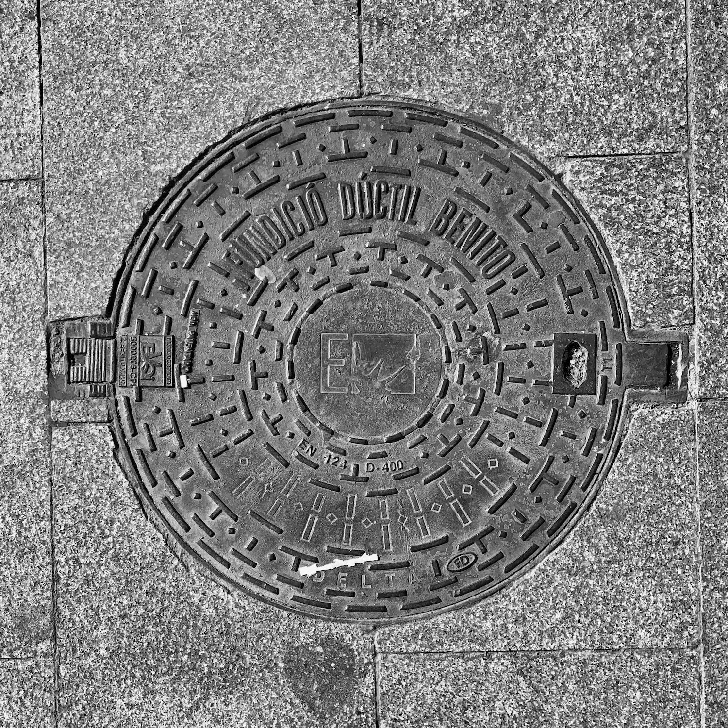 black and white image of a utility cover