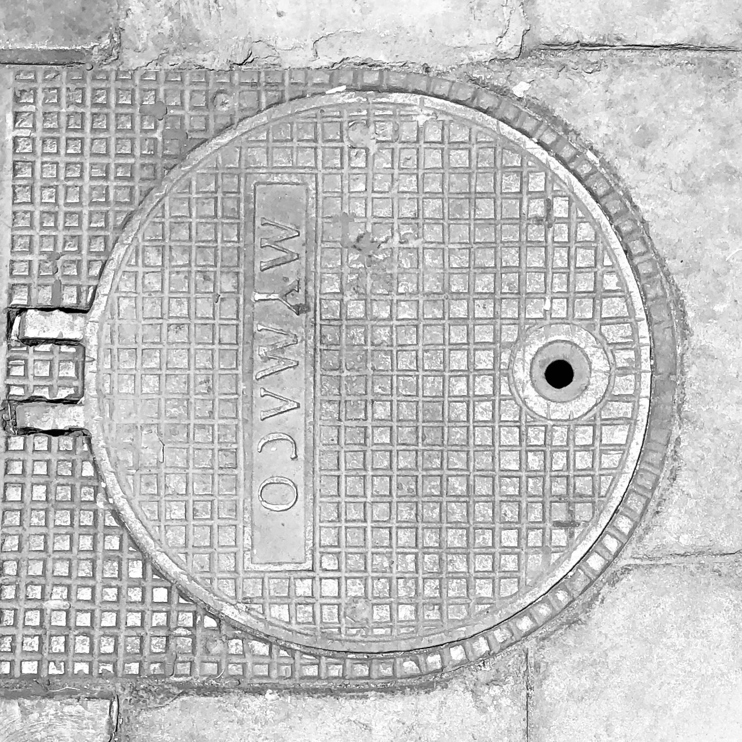 black and white image of a utility cover