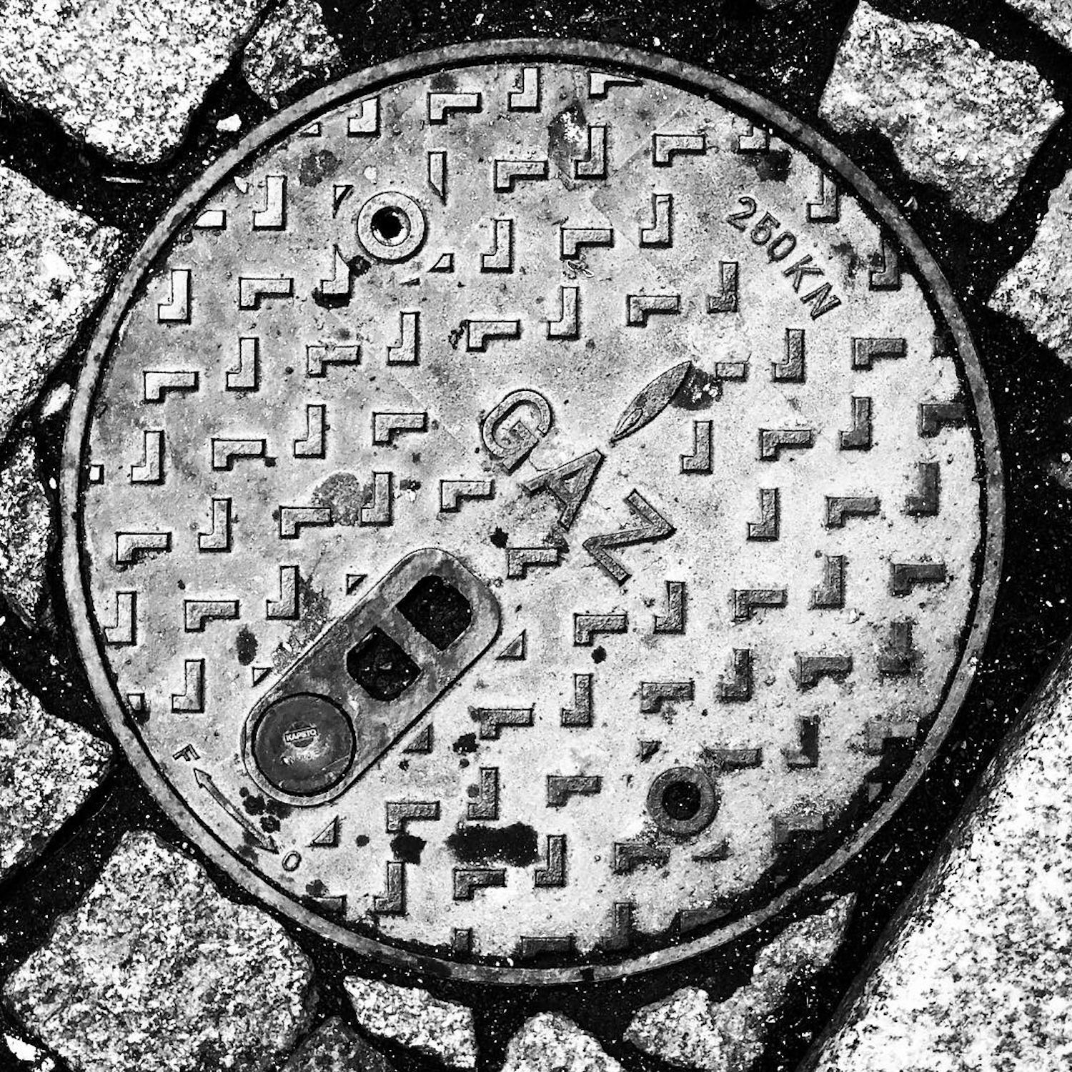 black and white image of a utility cover