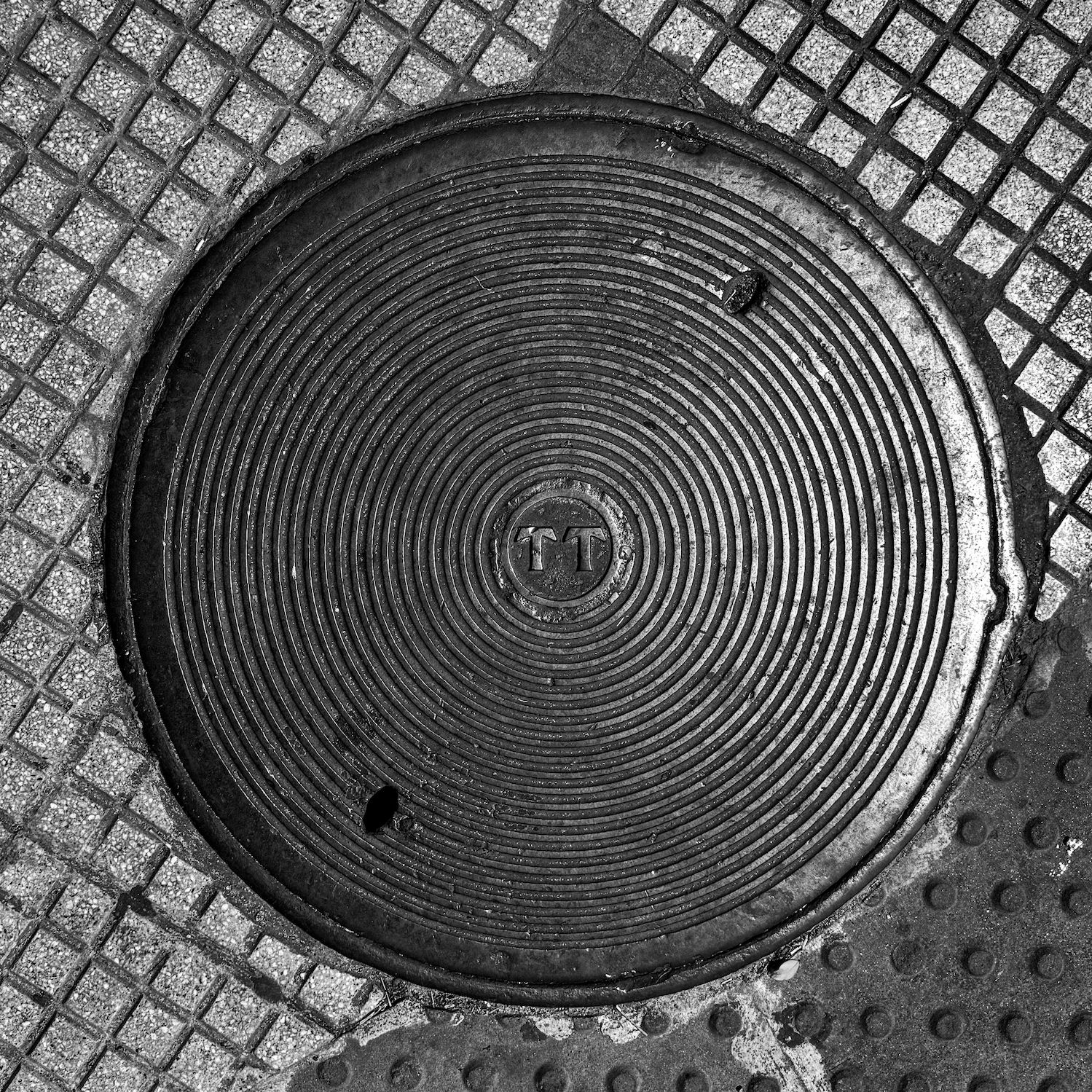 black and white image of a utility cover