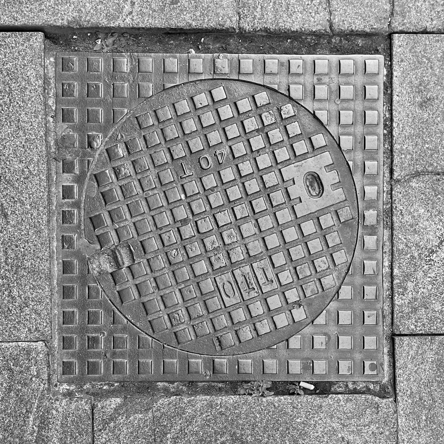 black and white image of a utility cover