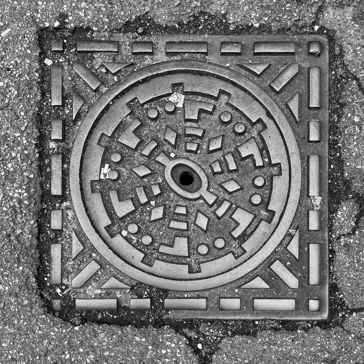 black and white image of a utility cover