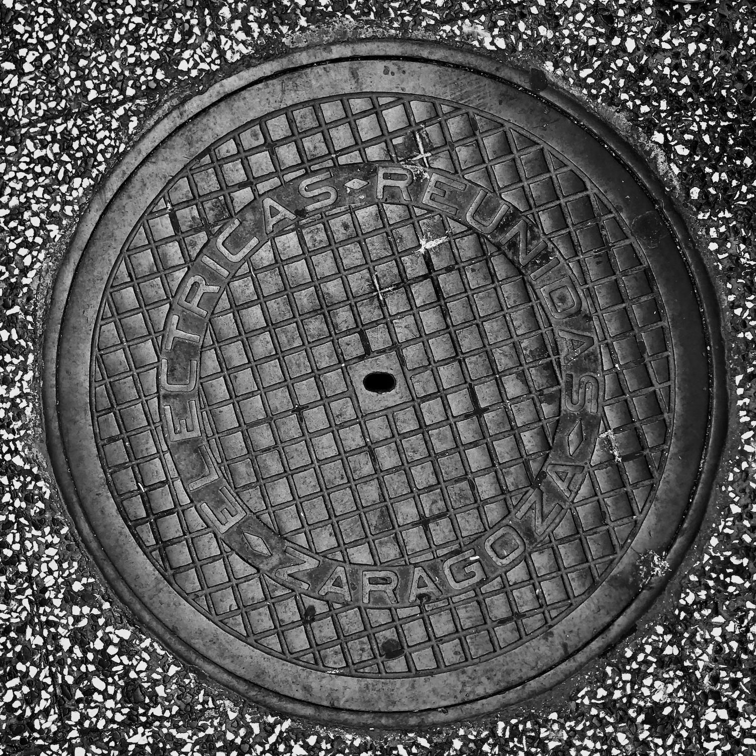 black and white image of a utility cover