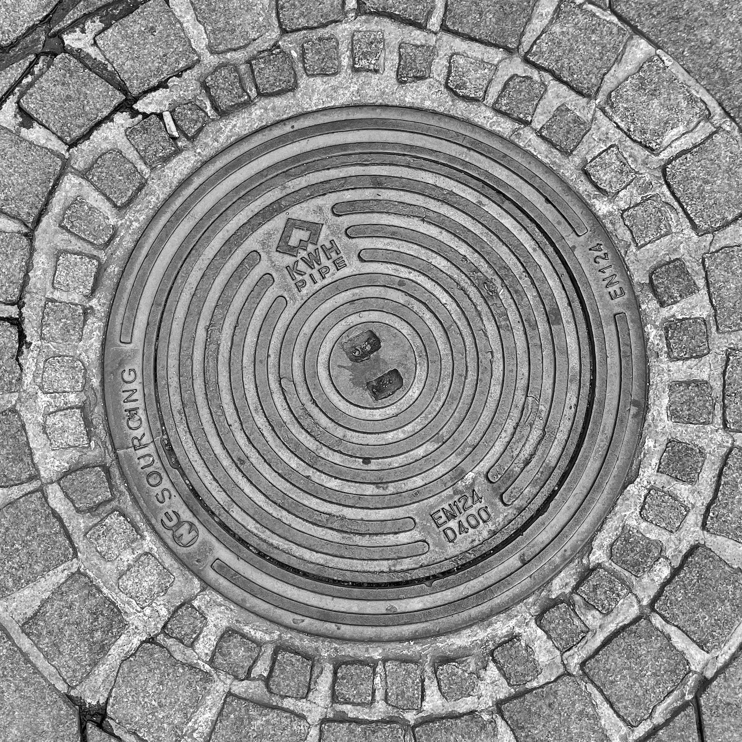 black and white image of a utility cover