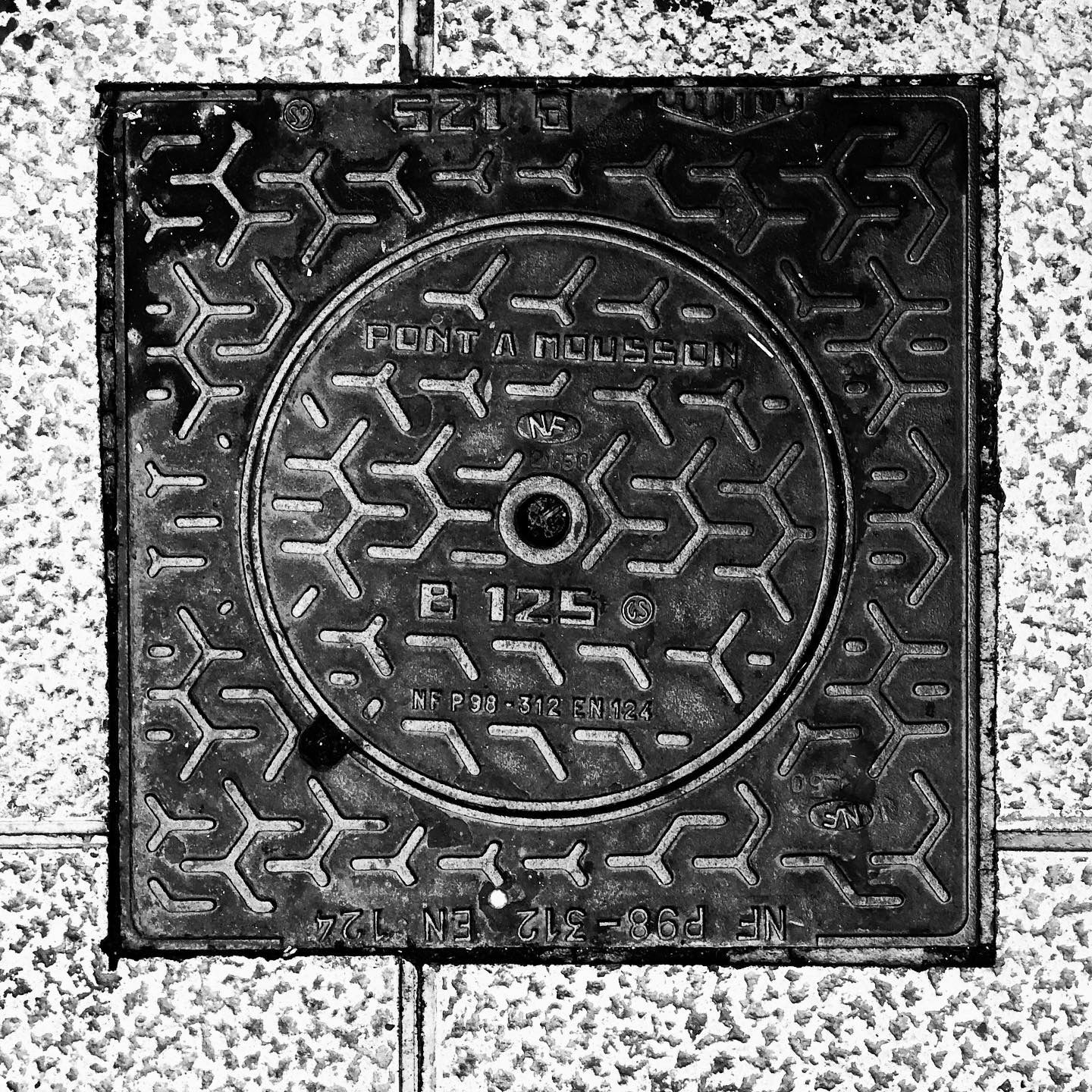 black and white image of a utility cover