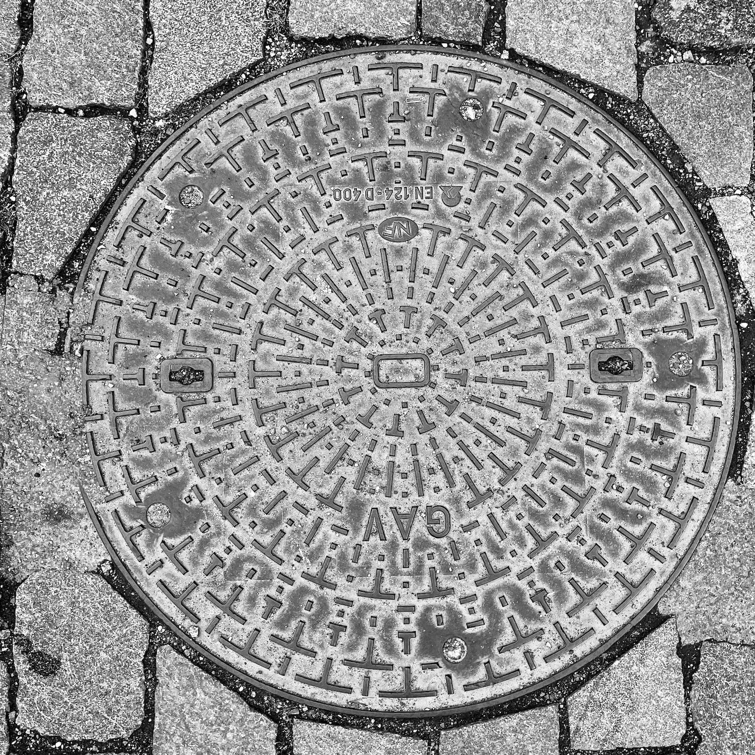 black and white image of a utility cover