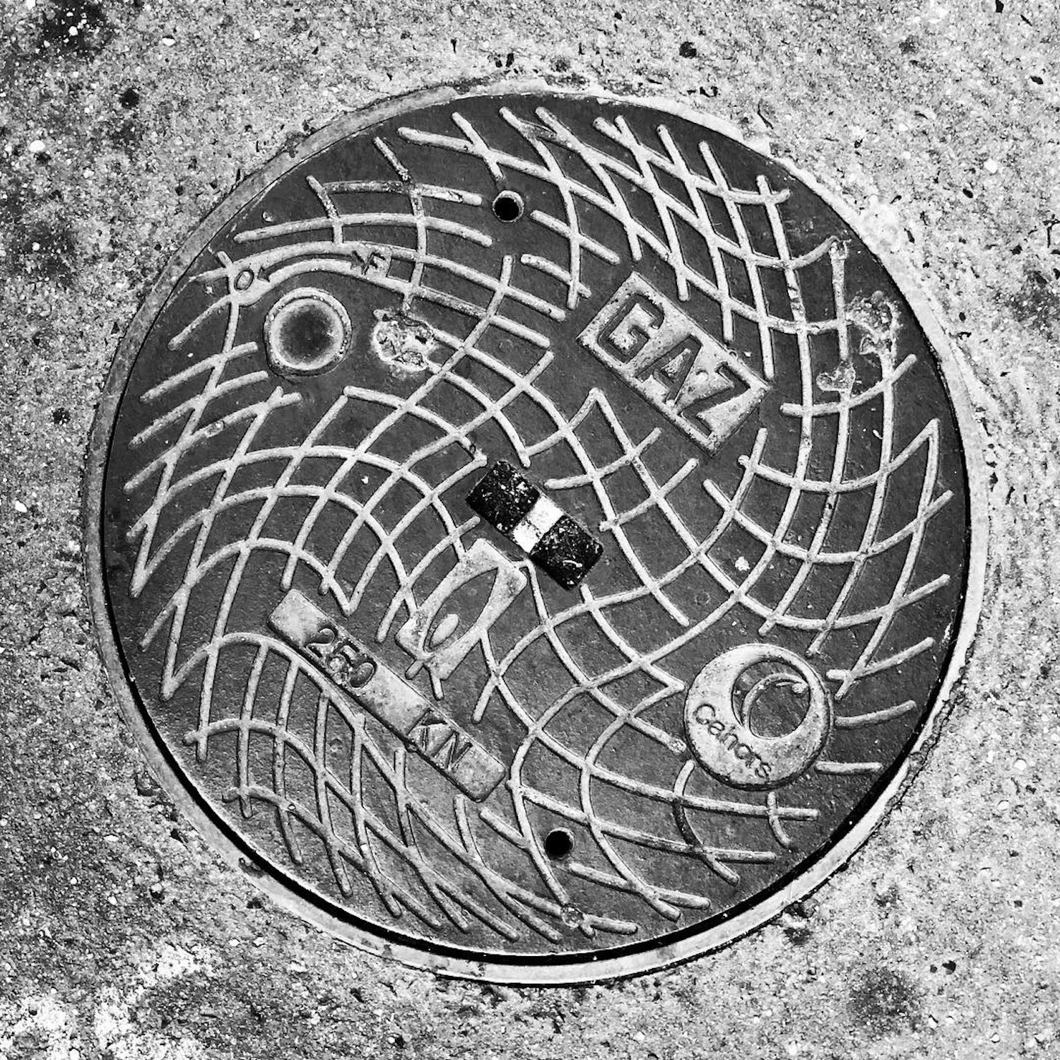 black and white image of a utility cover