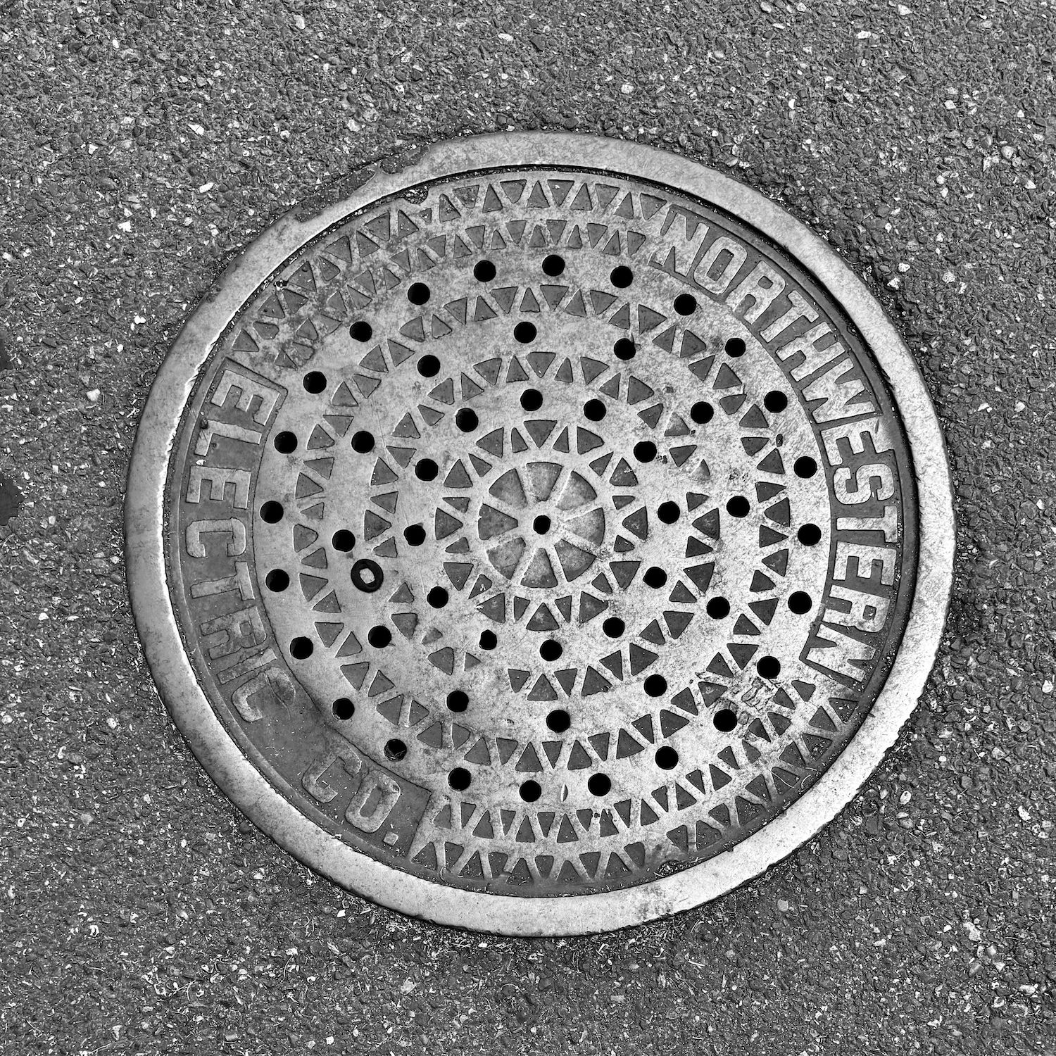 black and white image of a utility cover