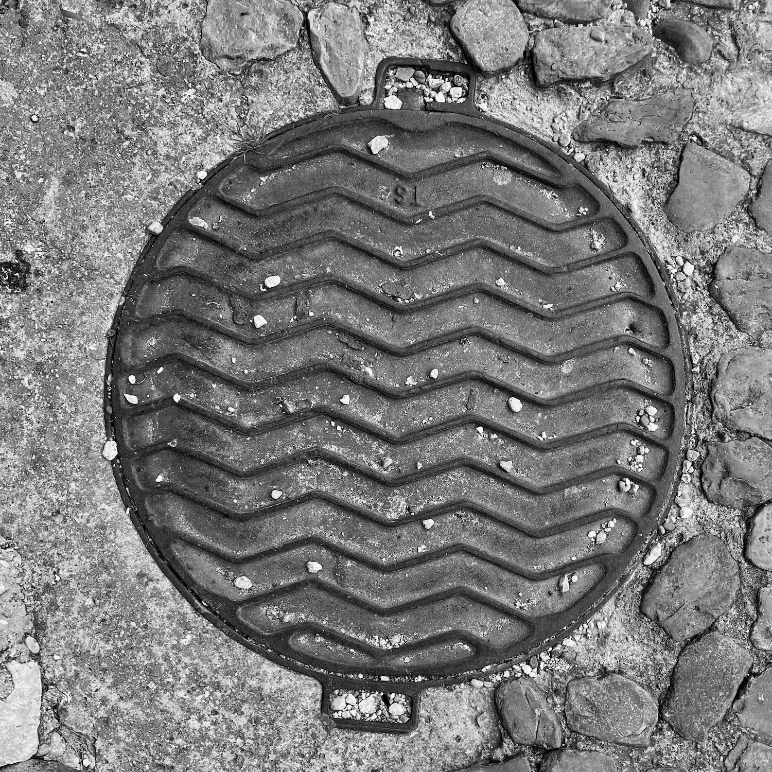 black and white image of a utility cover