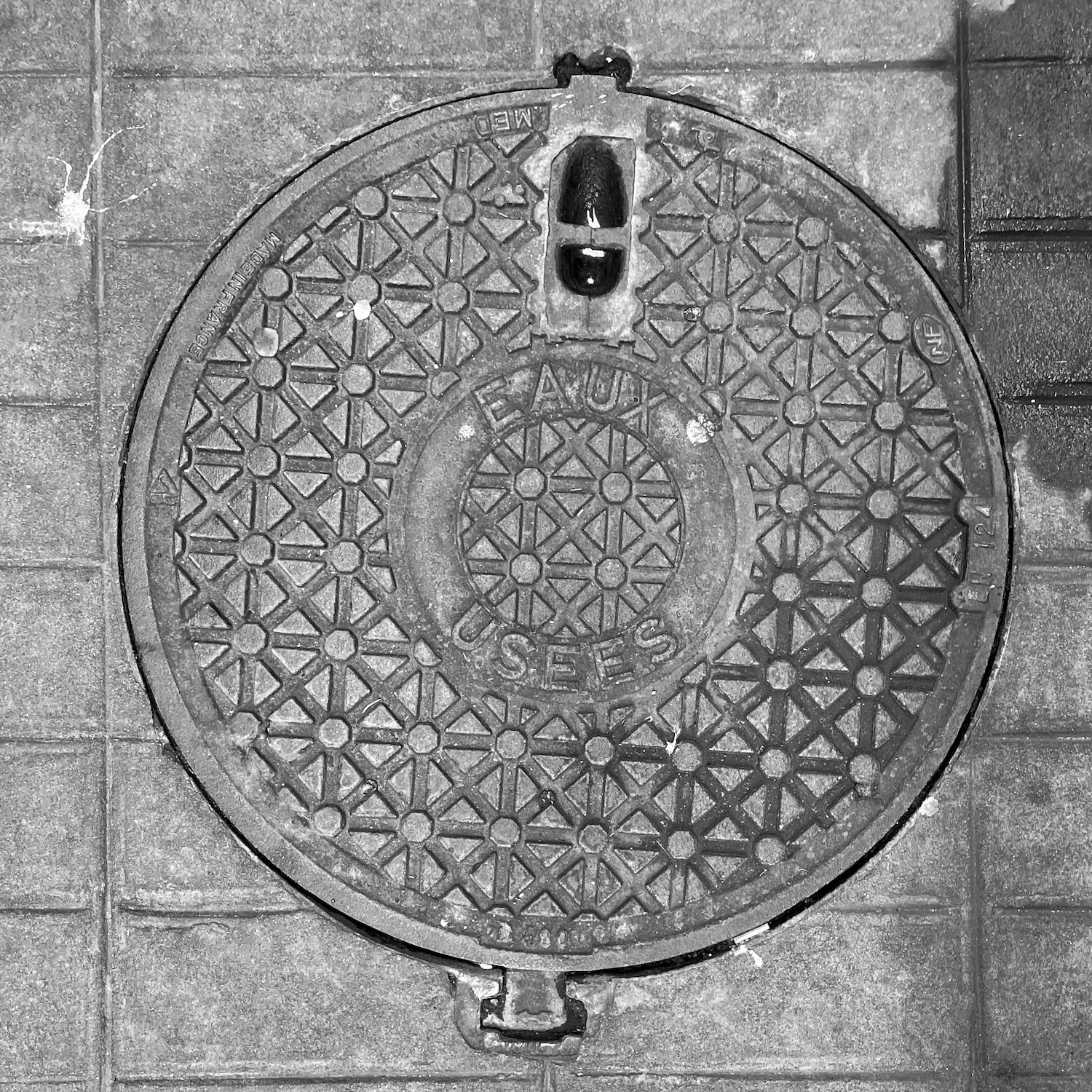 black and white image of a utility cover