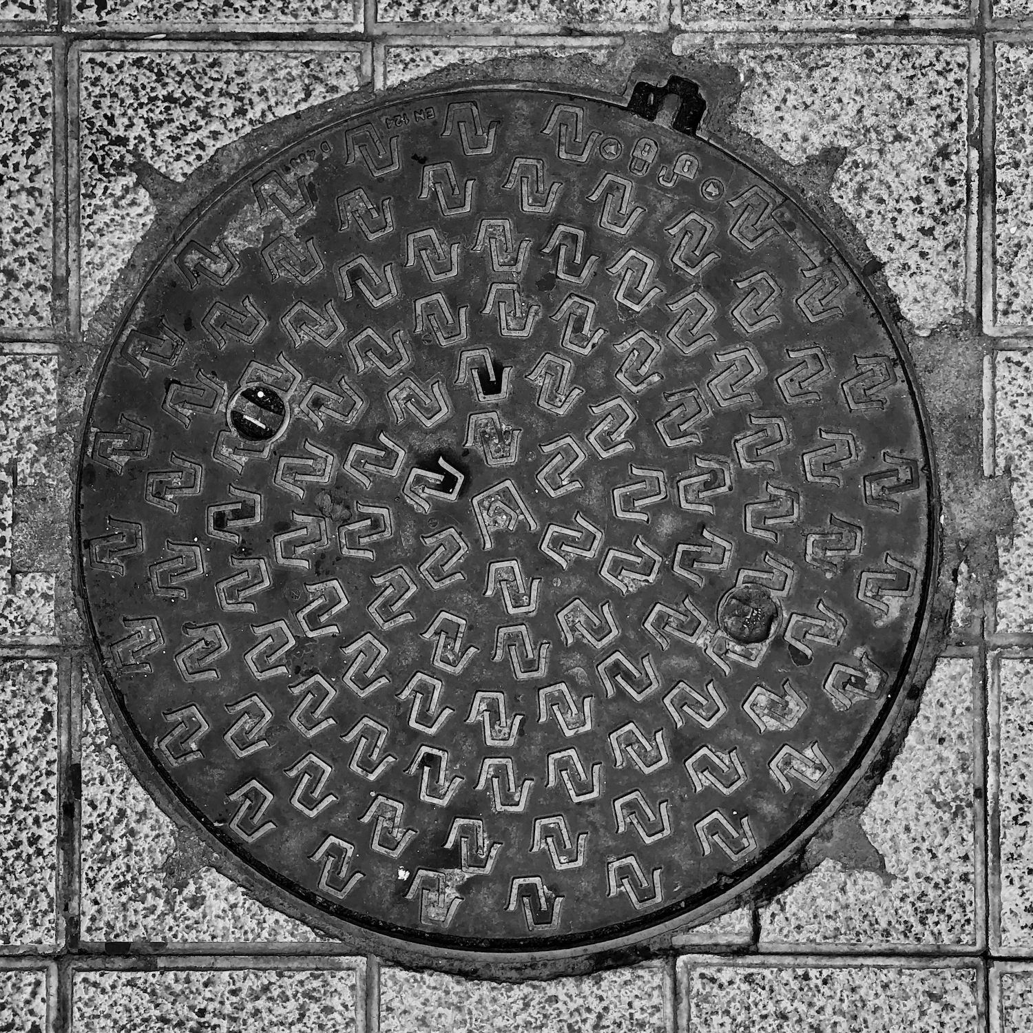 black and white image of a utility cover