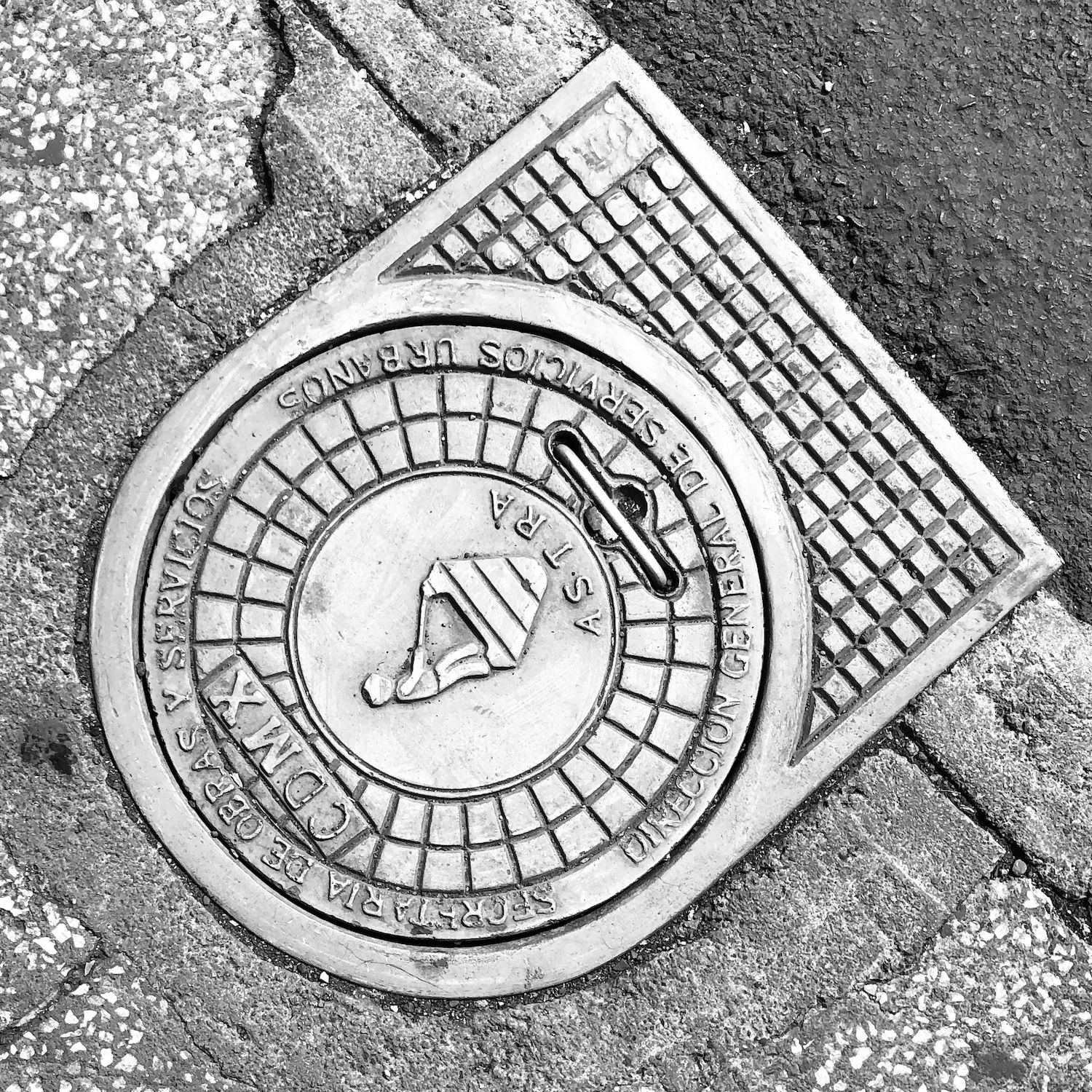 black and white image of a utility cover