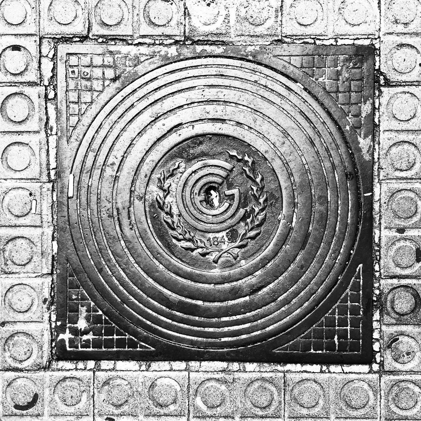 black and white image of a utility cover