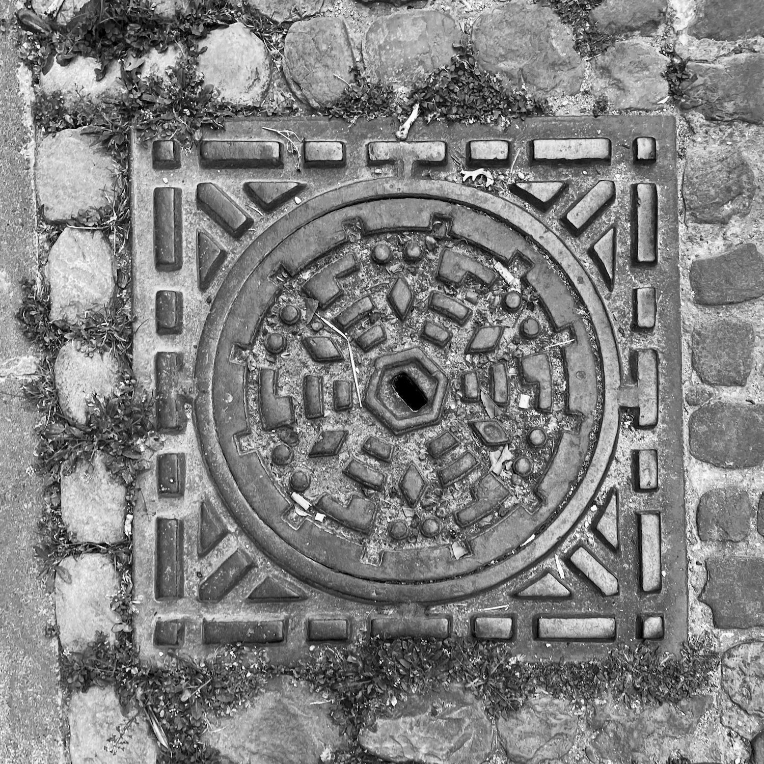 black and white image of a utility cover