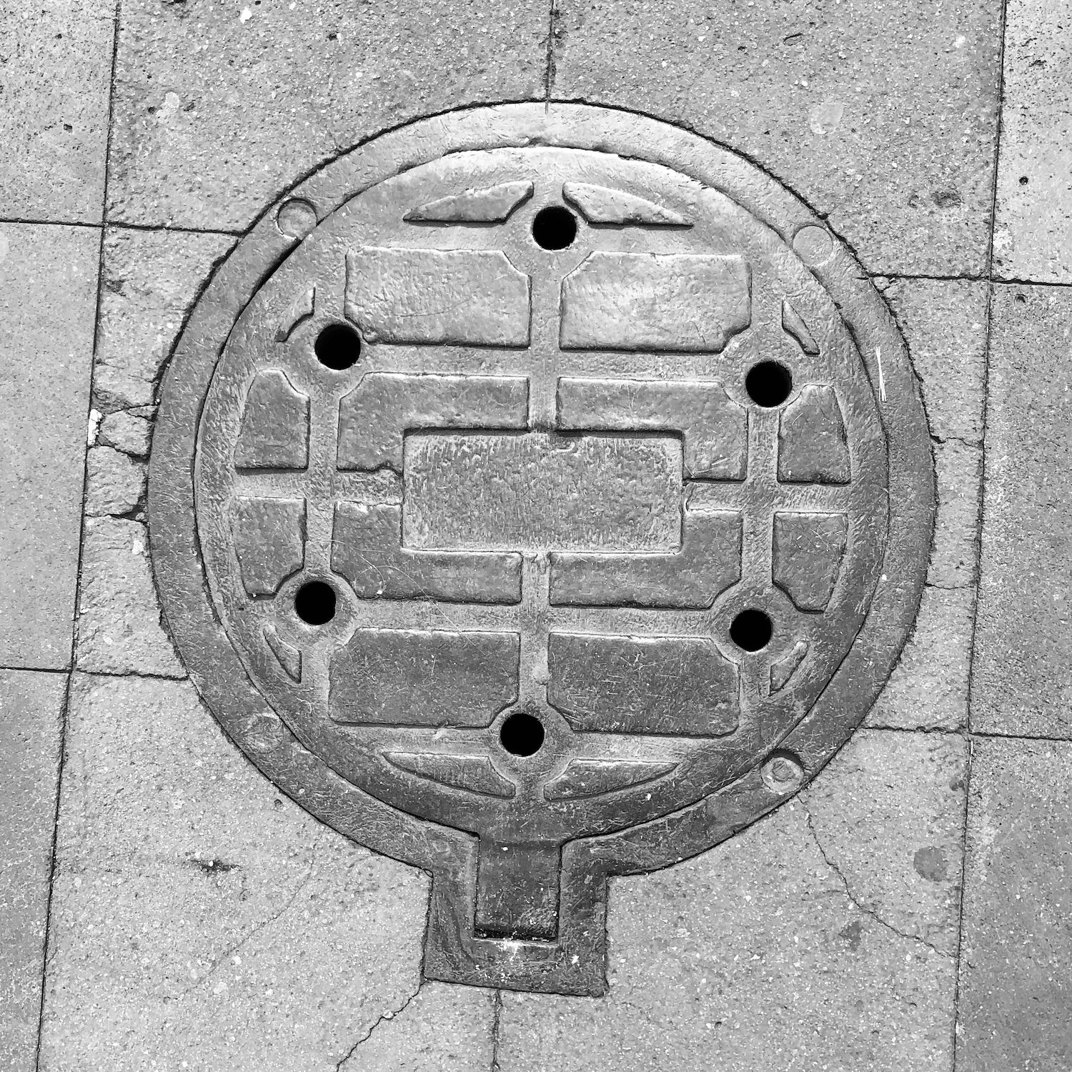black and white image of a utility cover