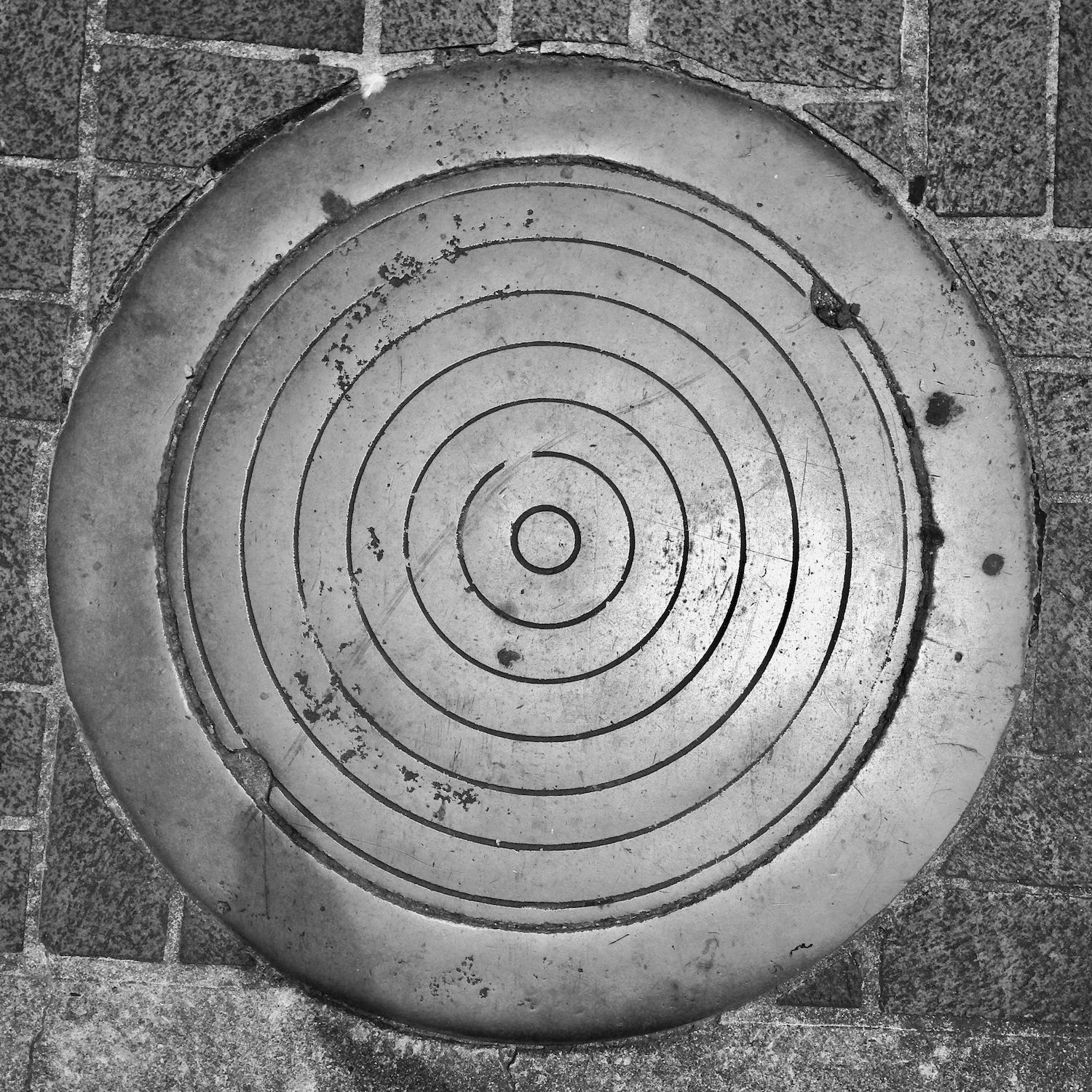 black and white image of a utility cover