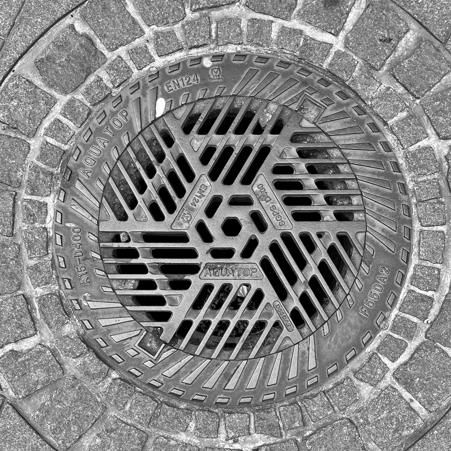 black and white image of a utility cover