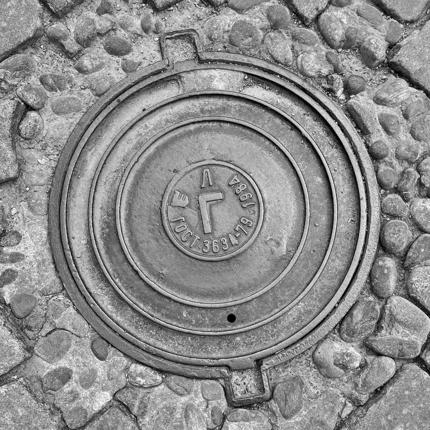 black and white image of a utility cover