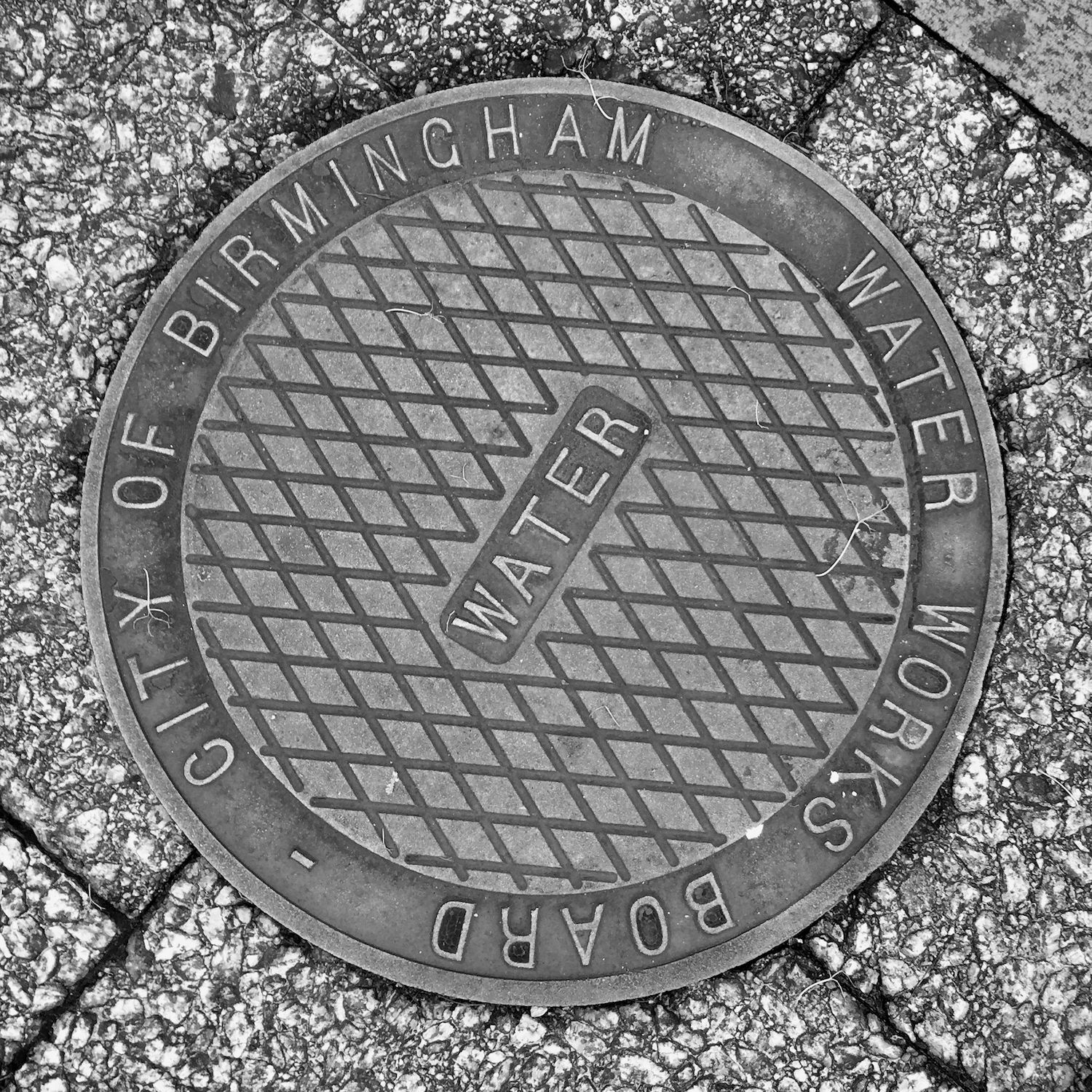 black and white image of a utility cover