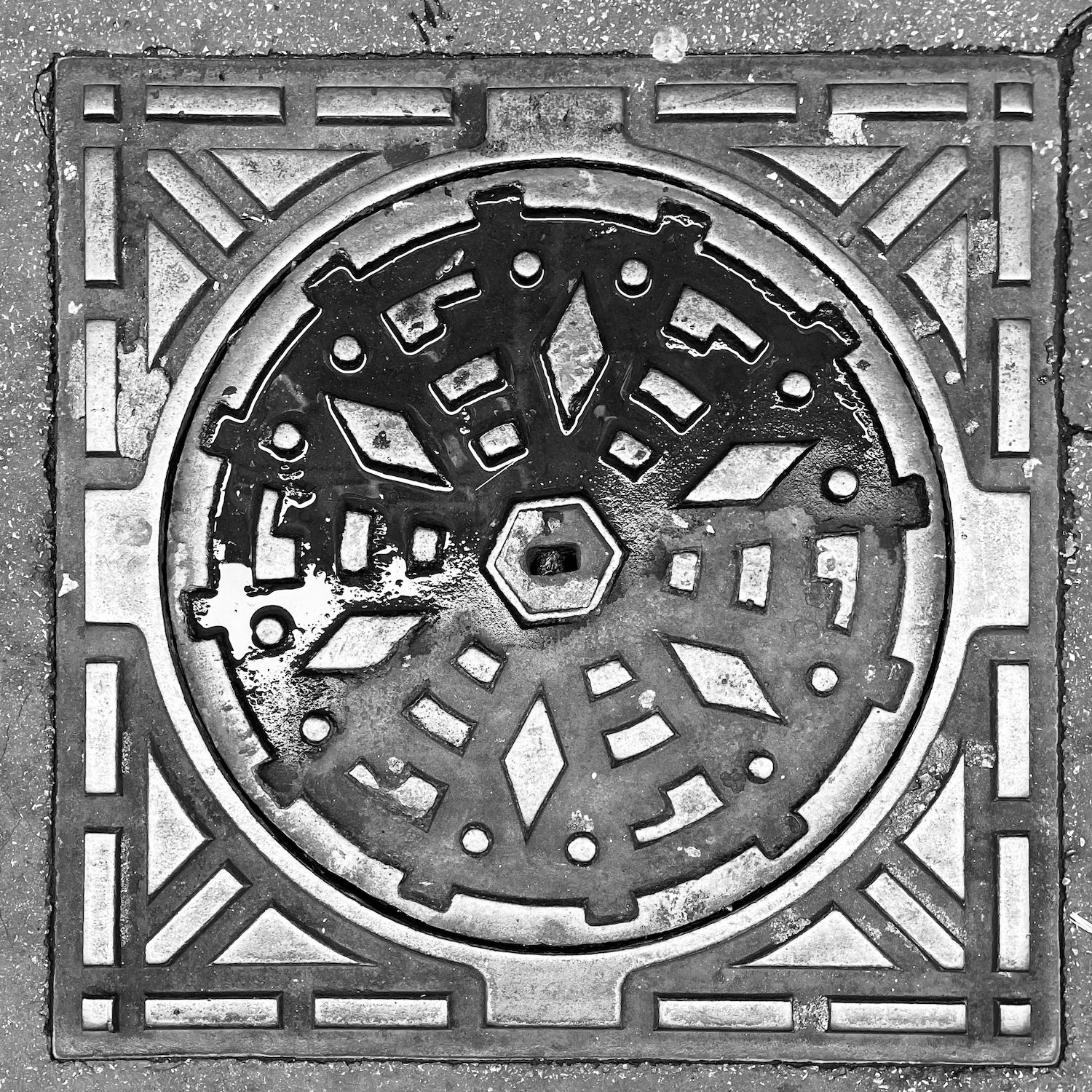 black and white image of a utility cover