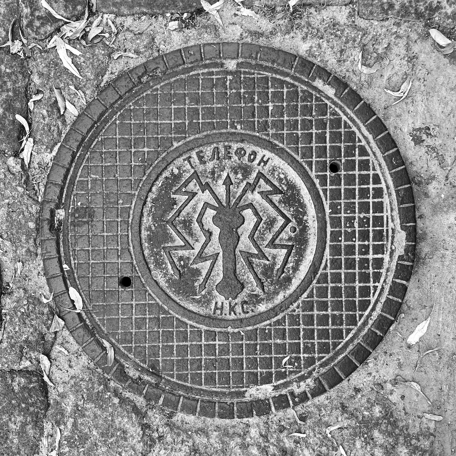 black and white image of a utility cover