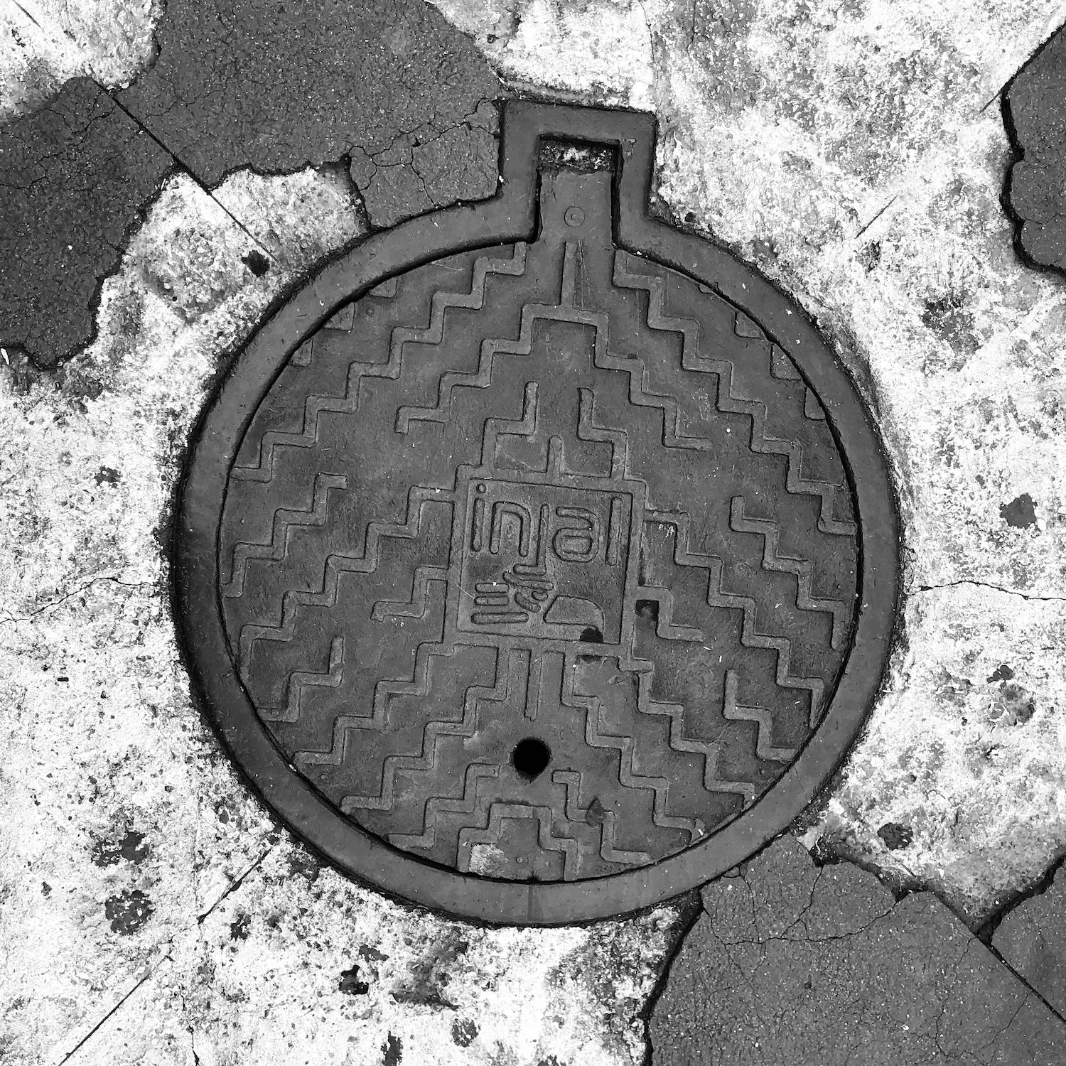 black and white image of a utility cover