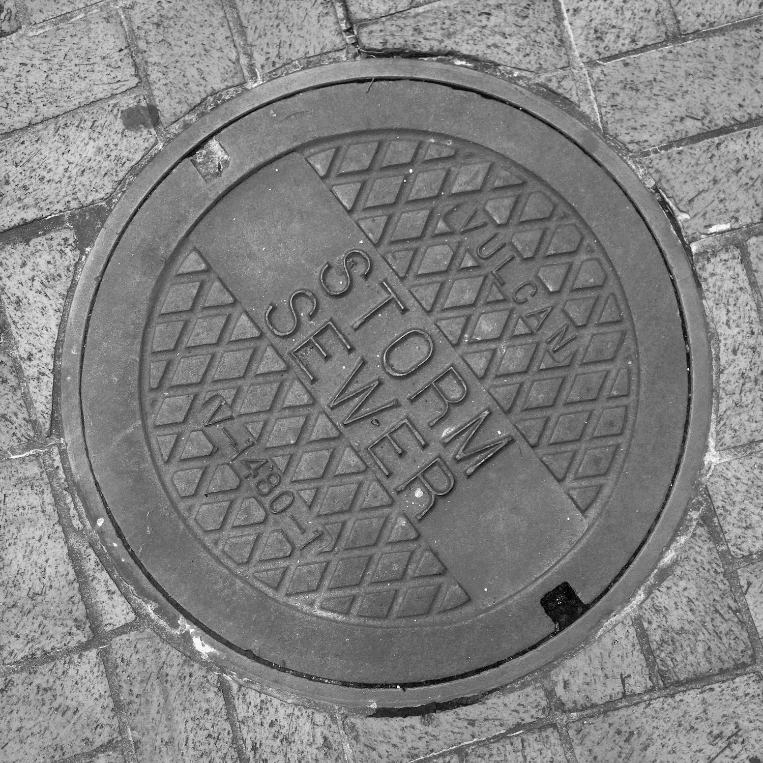 black and white image of a utility cover