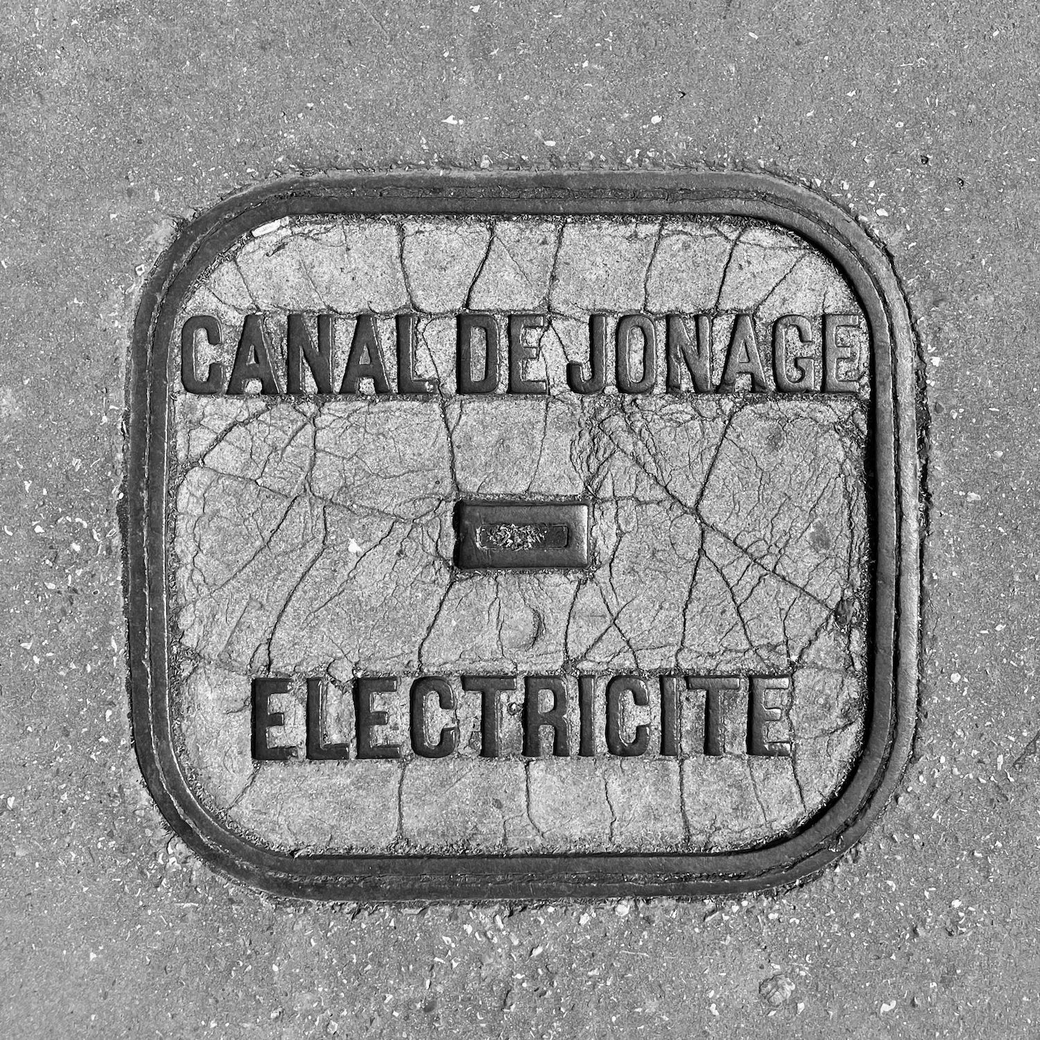 black and white image of a utility cover