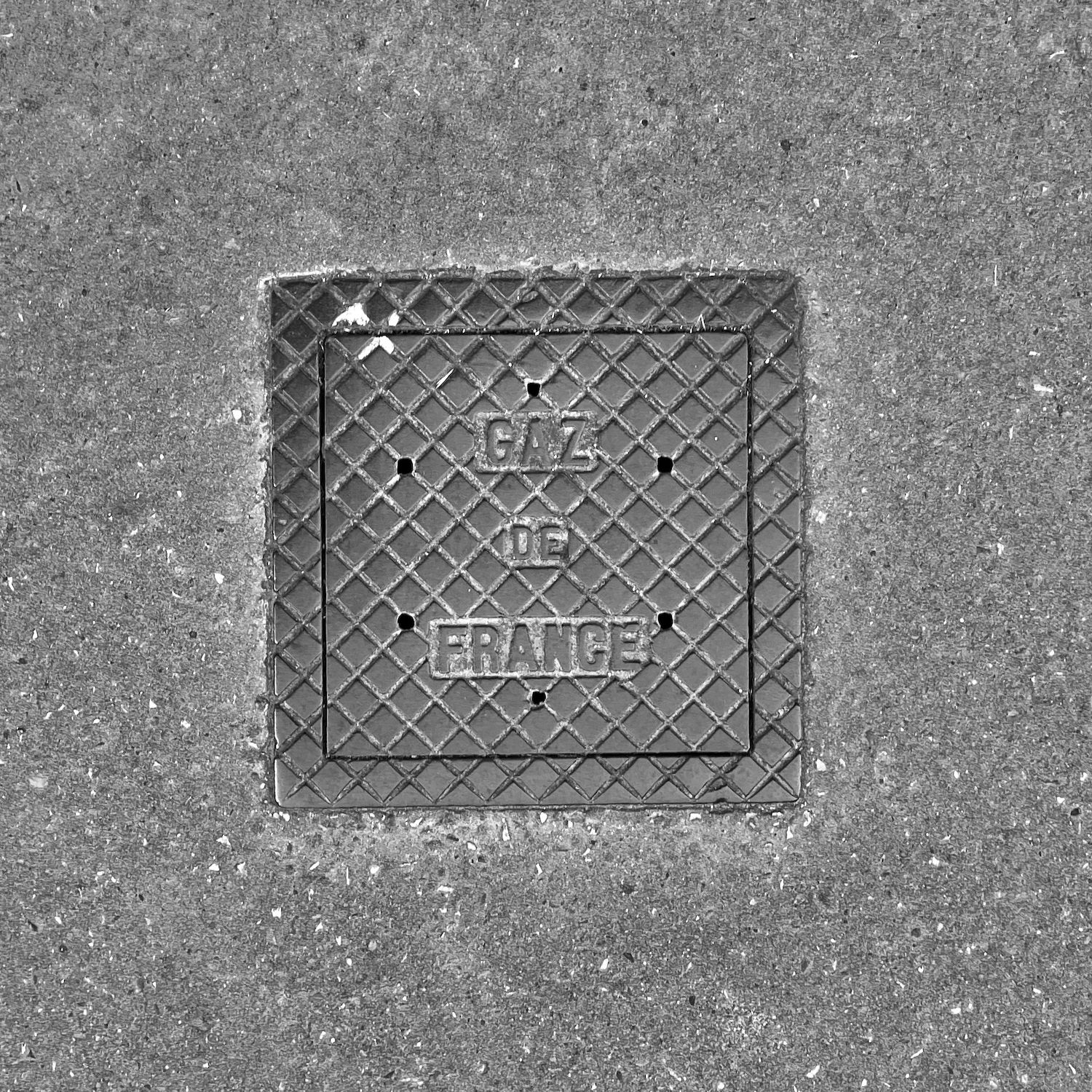 black and white image of a utility cover