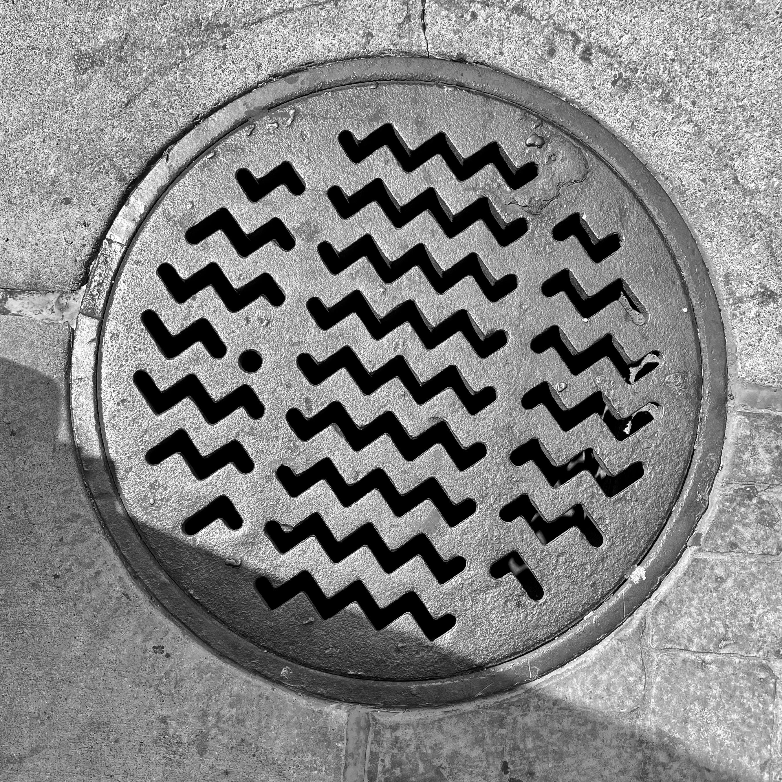 black and white image of a utility cover